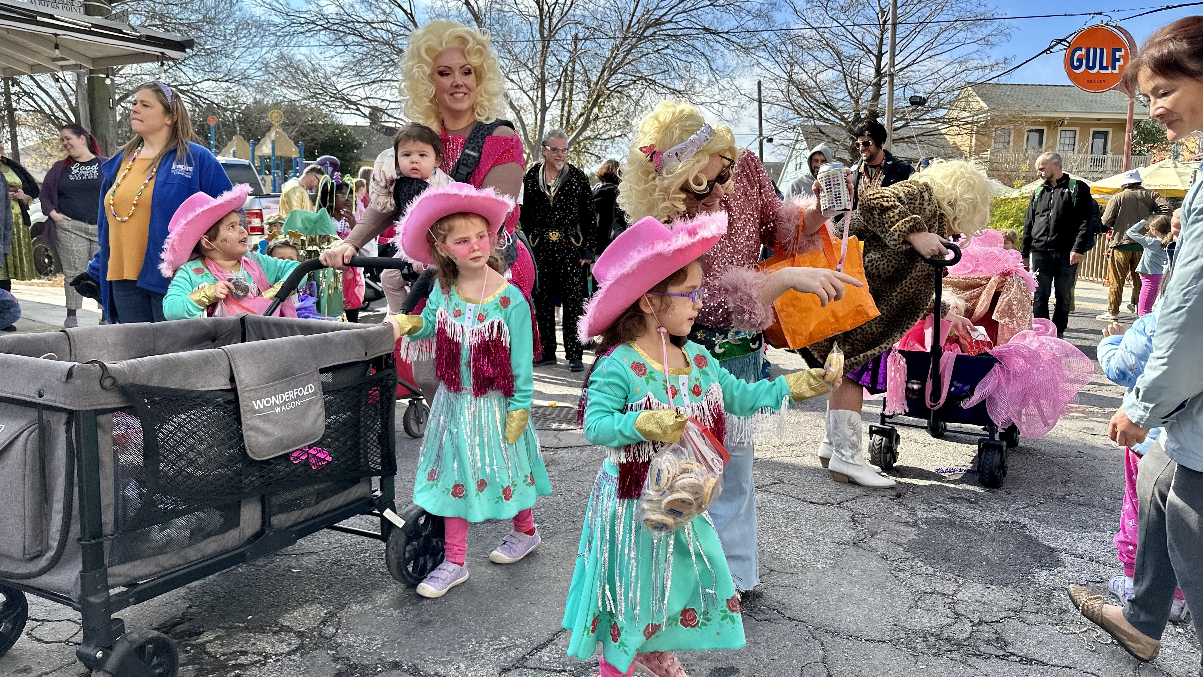 Photo shows children in costume walking in the Krewe of Confetti Kids parade in Algiers Point in New Orleans.