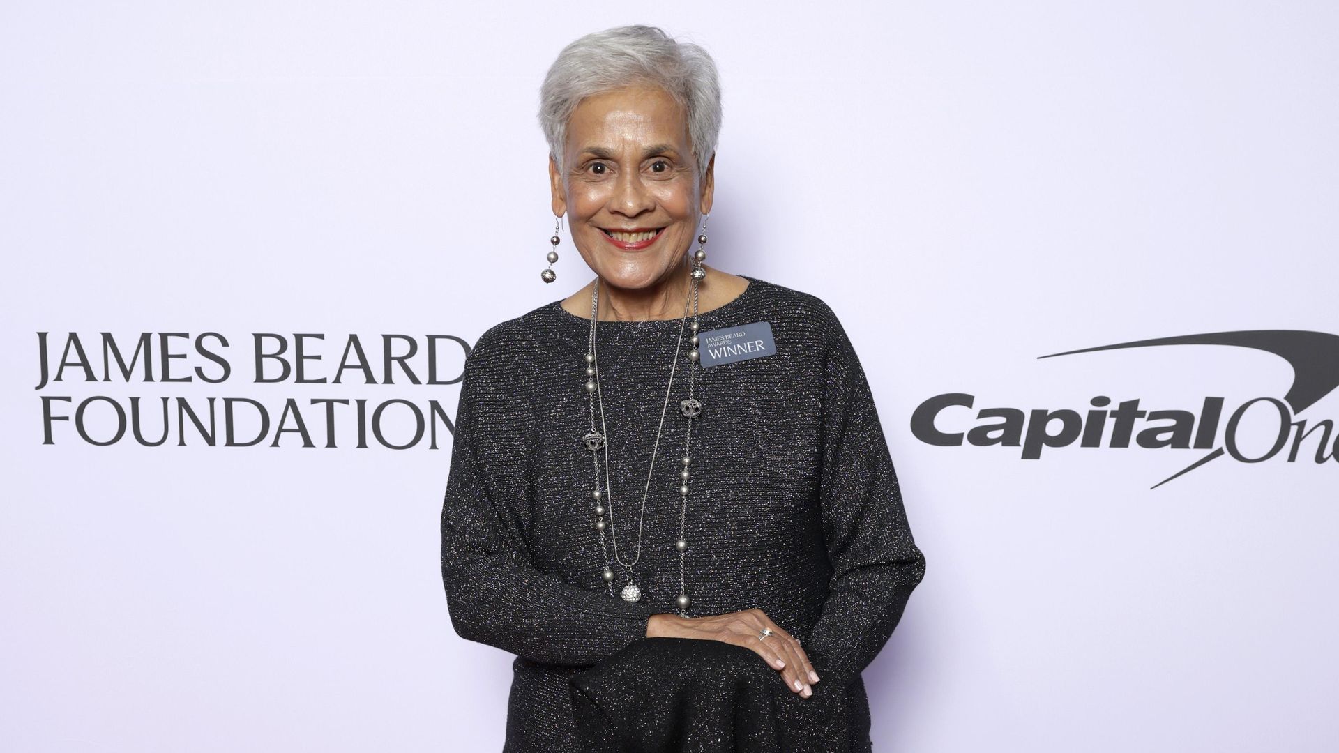 Photo shows Stella Chase Reese in a black gown on the red carpet at the James Beard Awards.