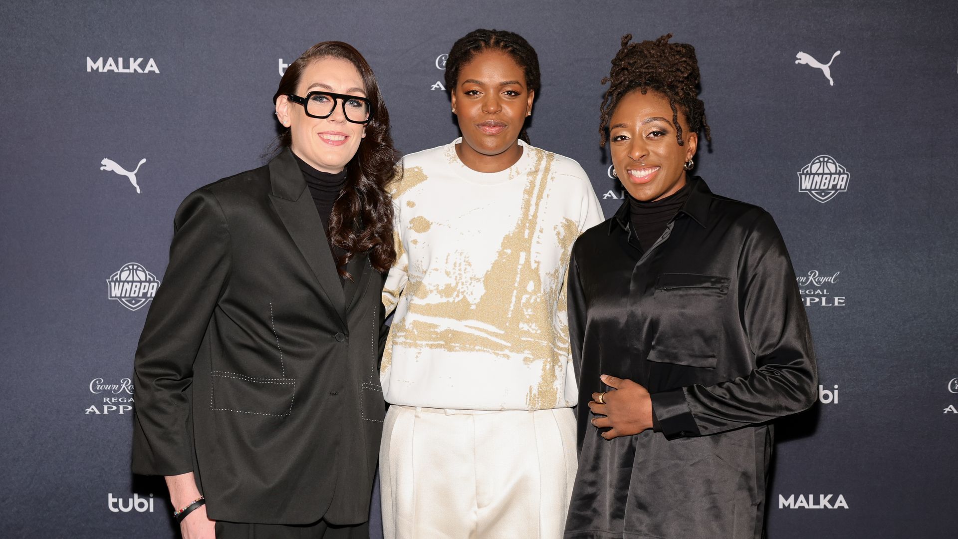 In this photo, Breanna Stewart, Jonquel Jones, and Nneka Oguwumike pose for a picture.