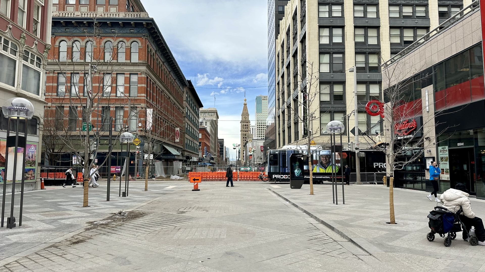 A photo of people walking on a completed stretch of the 16th Street Mall with construction in the background.