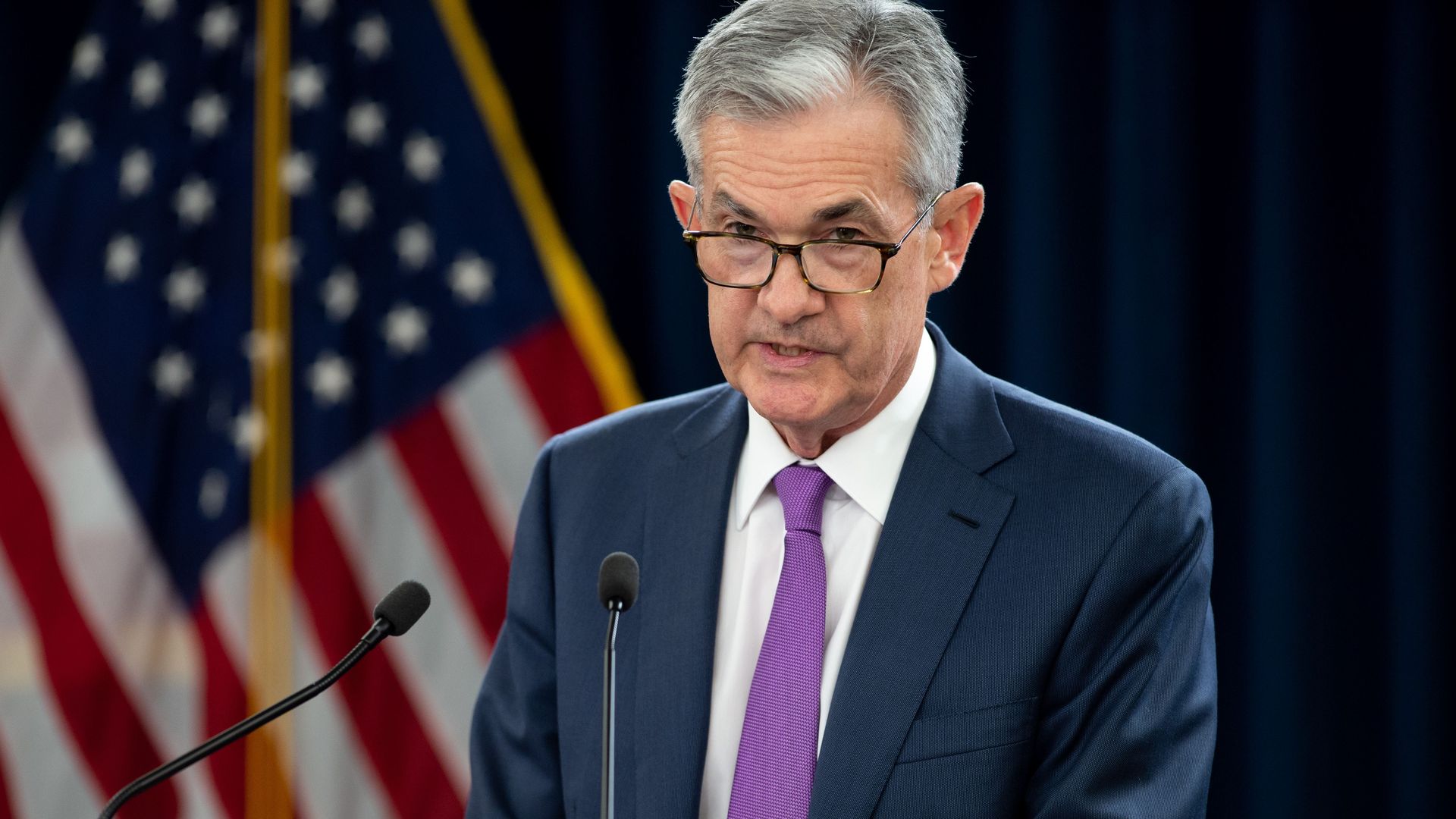 Federal Reserve Chairman Jerome Powell standing at a podium at a press conference.