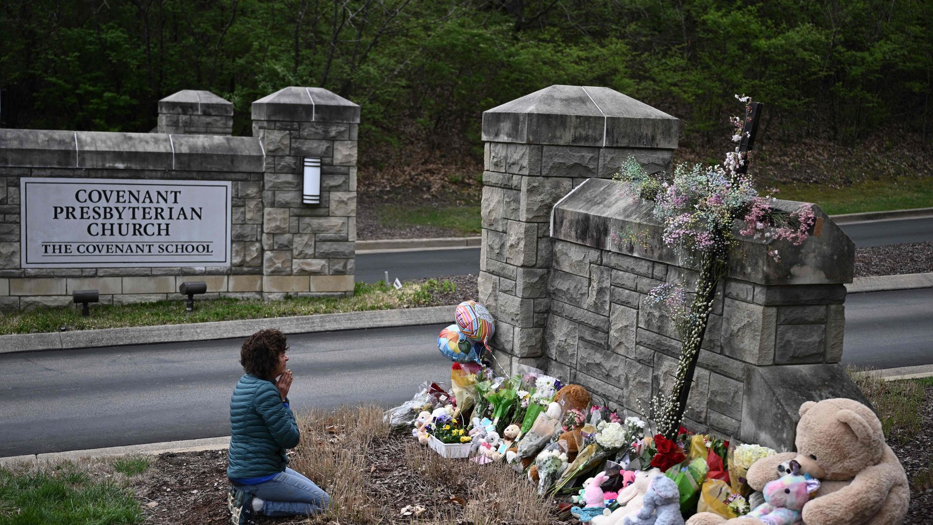Robin Wolfenden prays at a makeshift memorial for victims outside the Covenant School building