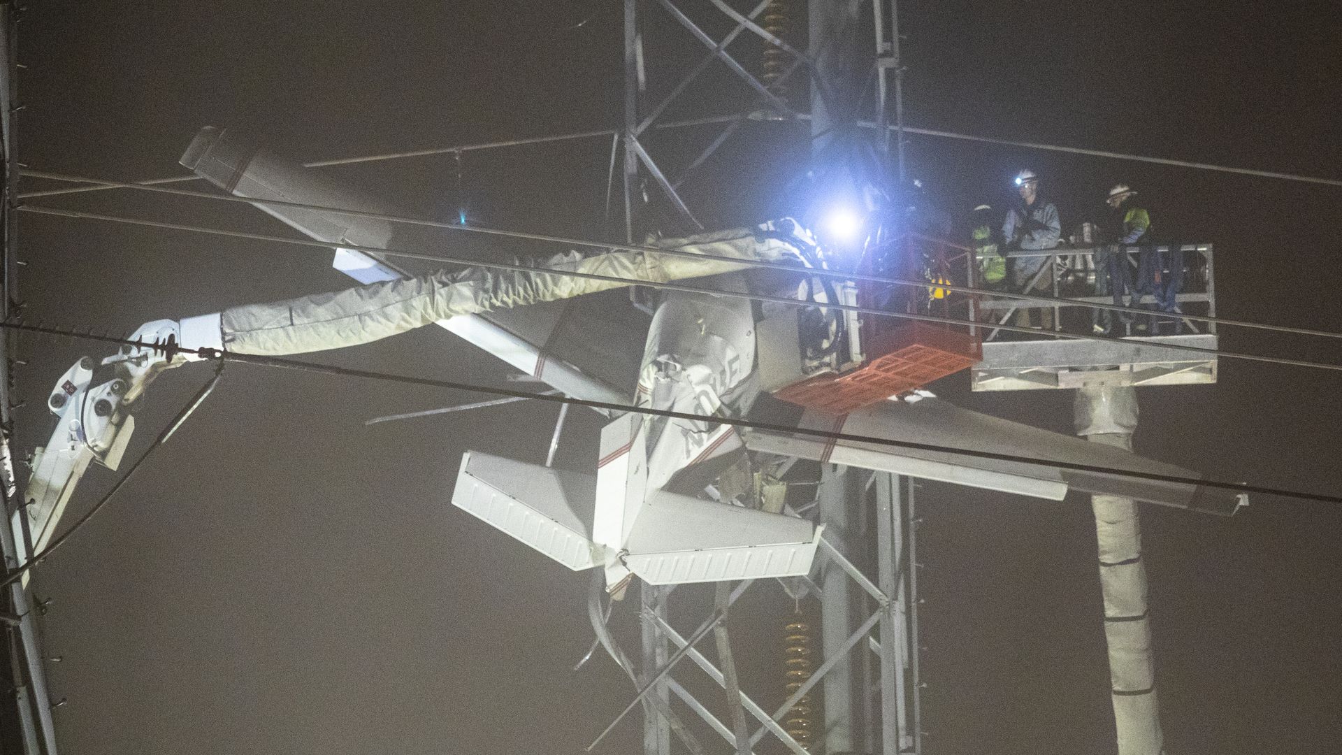 Emergency workers rescue people stuck in a plane that crashed into power lines. 