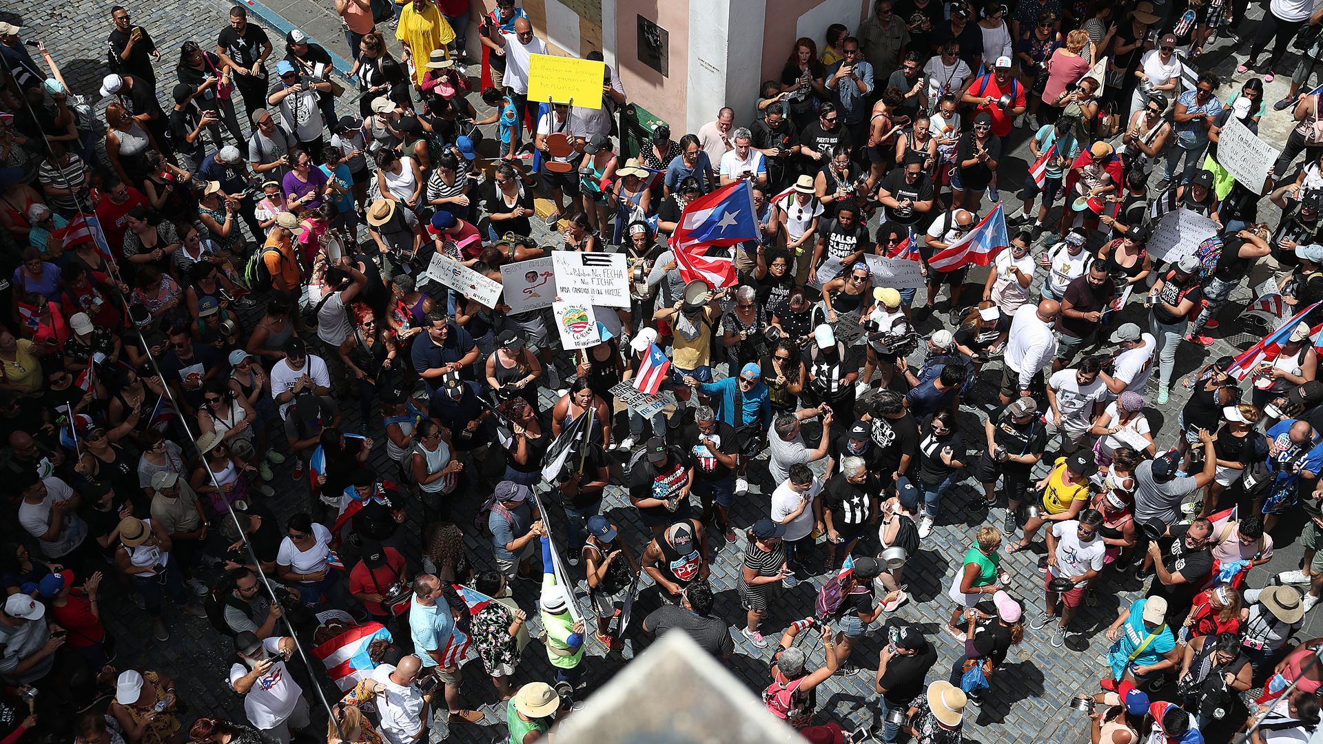 This image shows a birds eye view of an X shaped crosswalk that is crowded with people on all sides.
