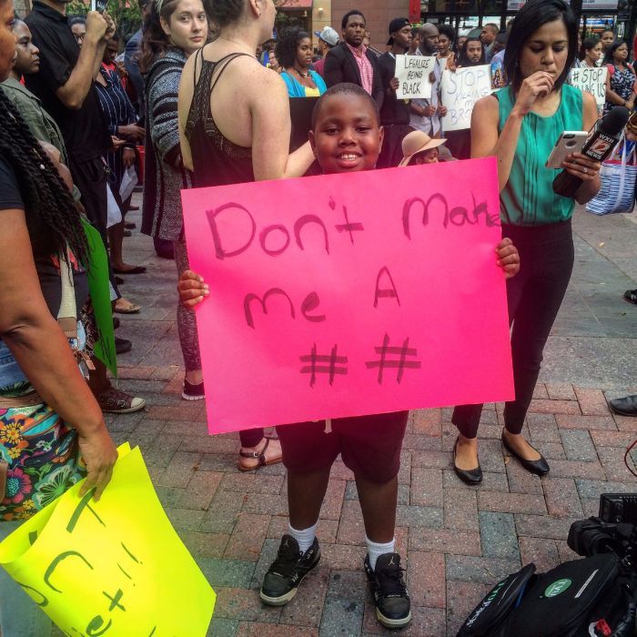 A 10-year-old boy holds his "Don't make me a hashtag" sign at Trade & Tryon