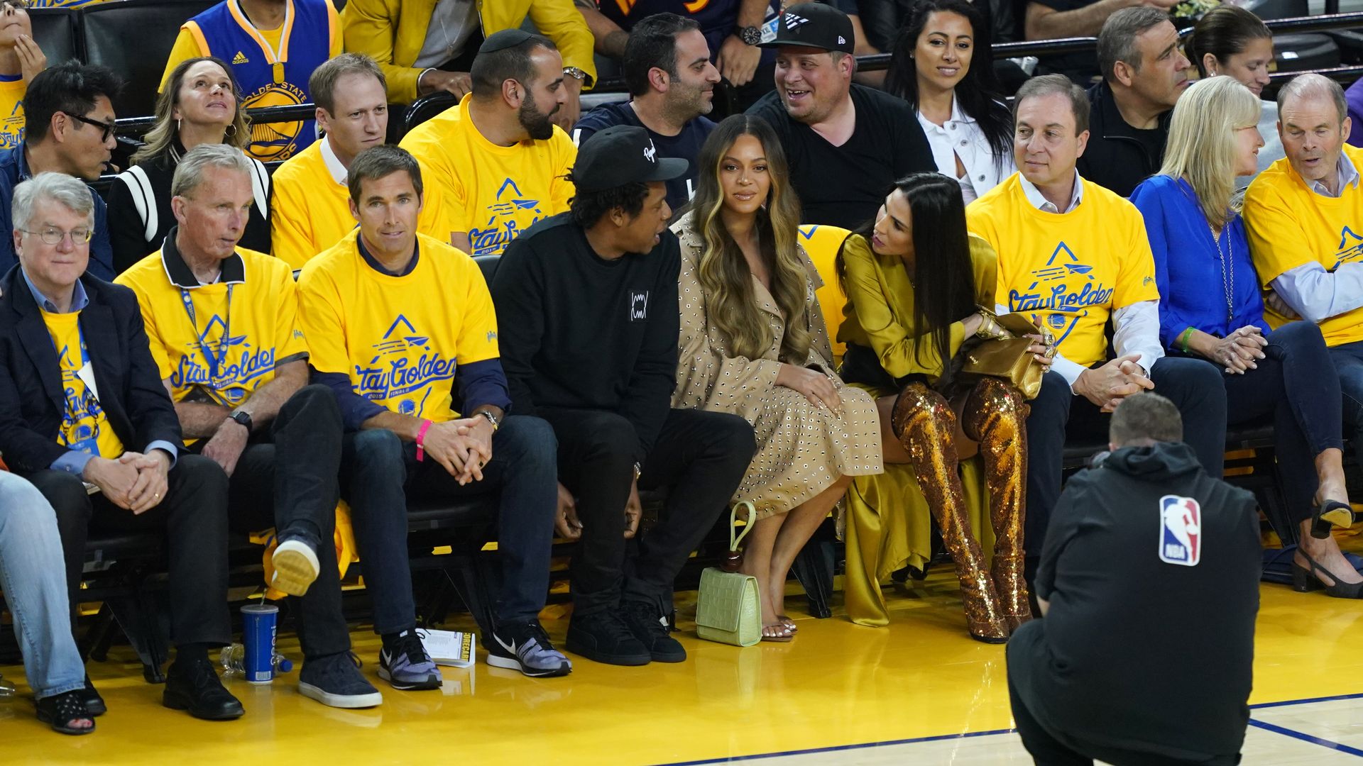 Nicole Curran talks to Jay-Z as Beyoncé looks on.