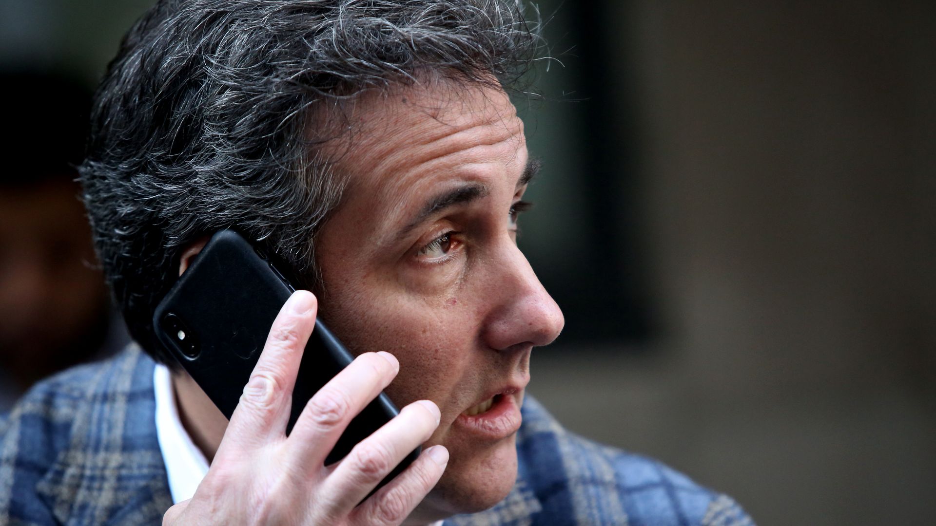 Michael Cohen holds a phone to his ear