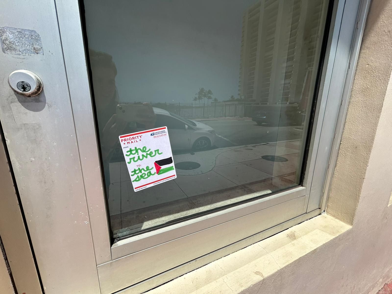 A postage sticker says "from the river to the sea" and features a Palestinian flag.