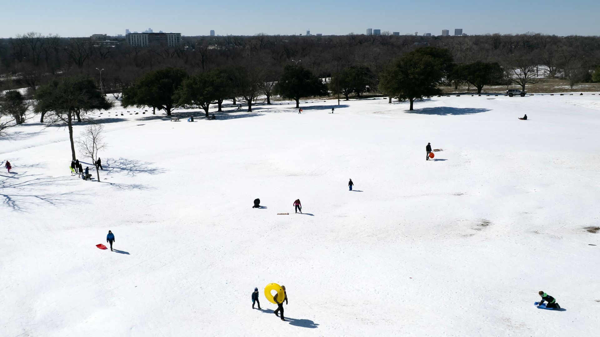 People sled down a hill filled with ice and snow