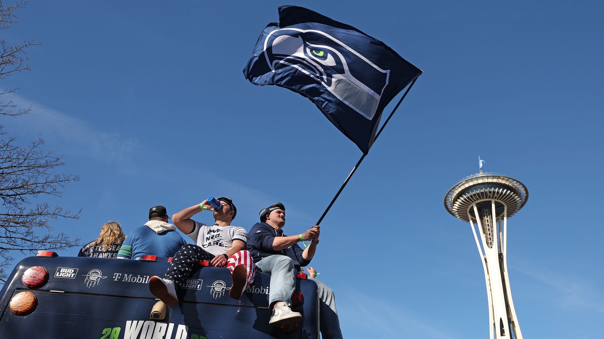Seahawks players hold a Hawks fan as the parade convoy nears the Space Needle.