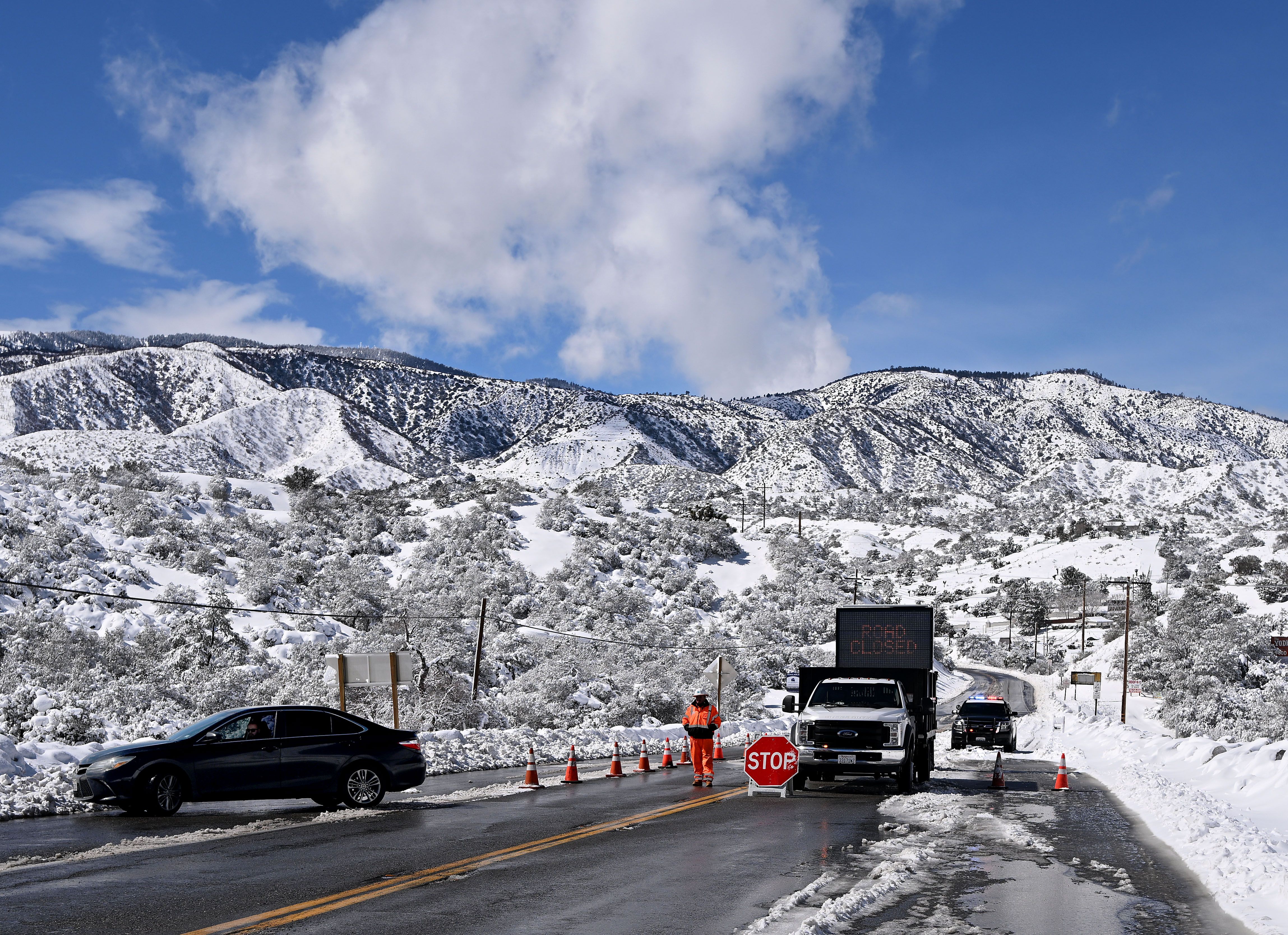 A Cal Trans employee turns away a driver as they attempted to gain access to Wrightwood on Highway 2 near Highway 138 Wednesday, Mar. 1,.