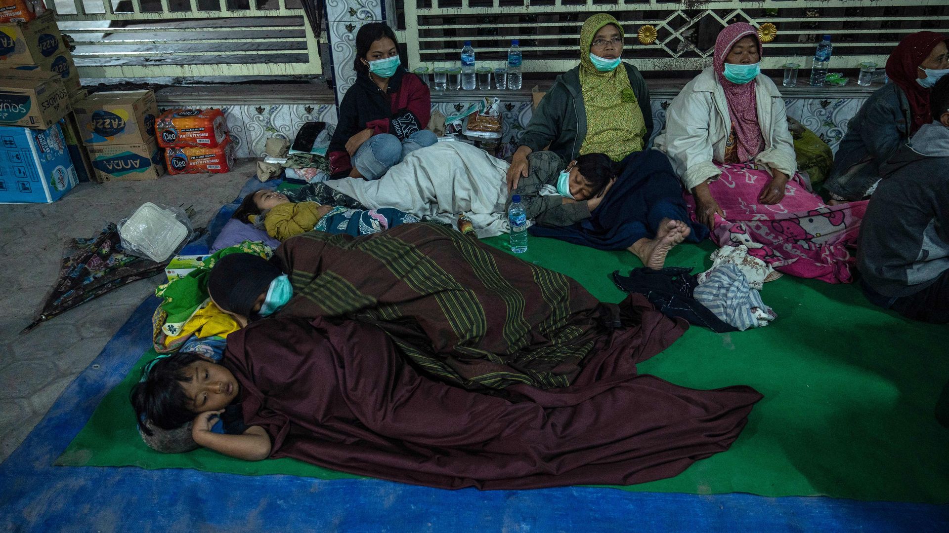 Evacuees take shelter at the local mosque of Sumber Wuluh village, in Lumajang, on December 5, 2021, after the eruption of Semeru volcano.