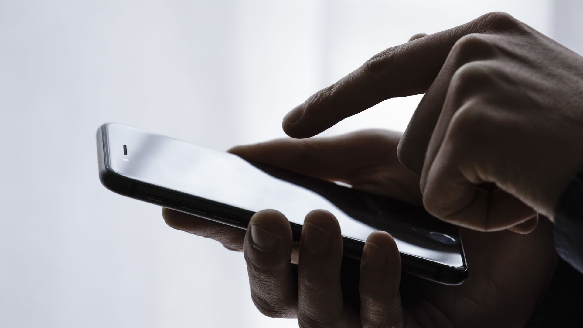 Hands typing on a smartphone