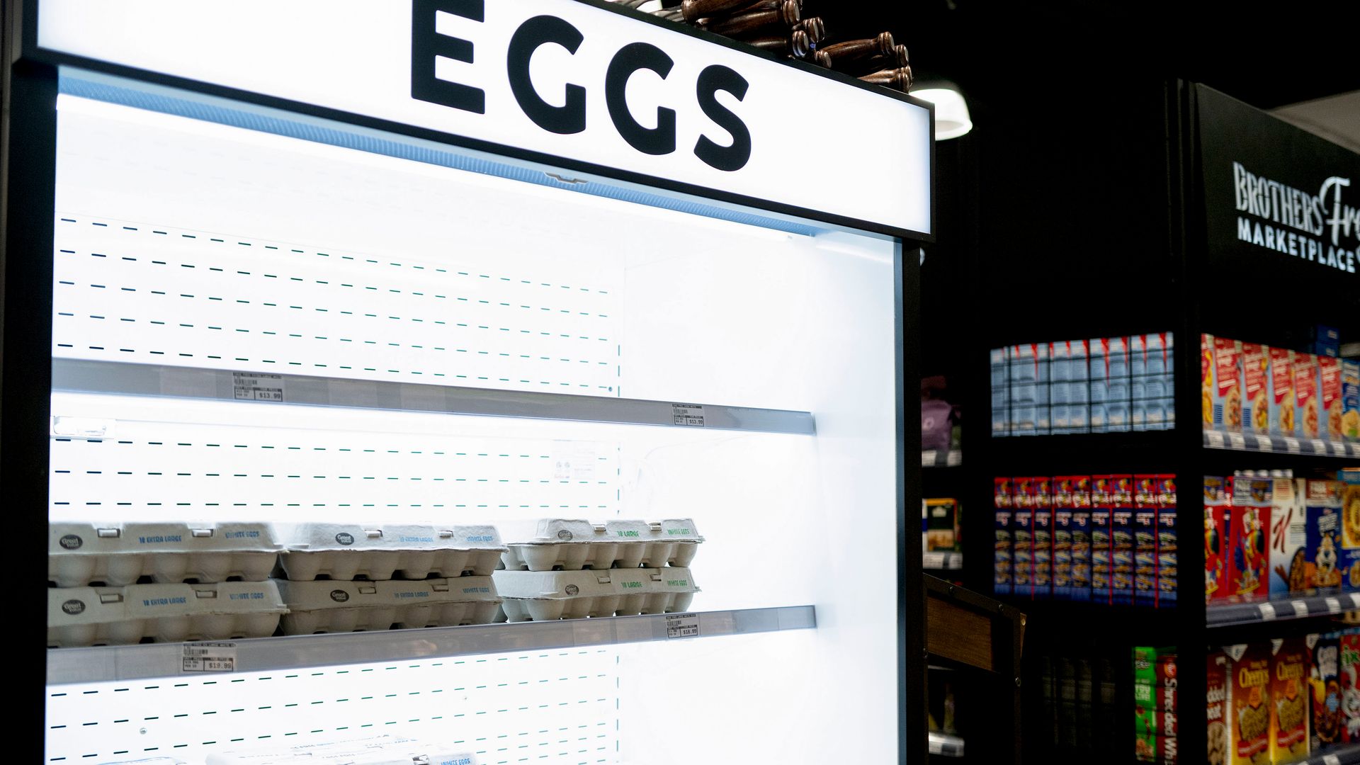 Store display that says eggs with a few dozen eggs in the display and shelves that are empty