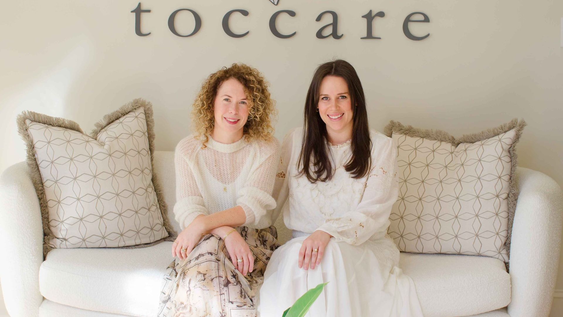 Cristina and Caci sit on a couch