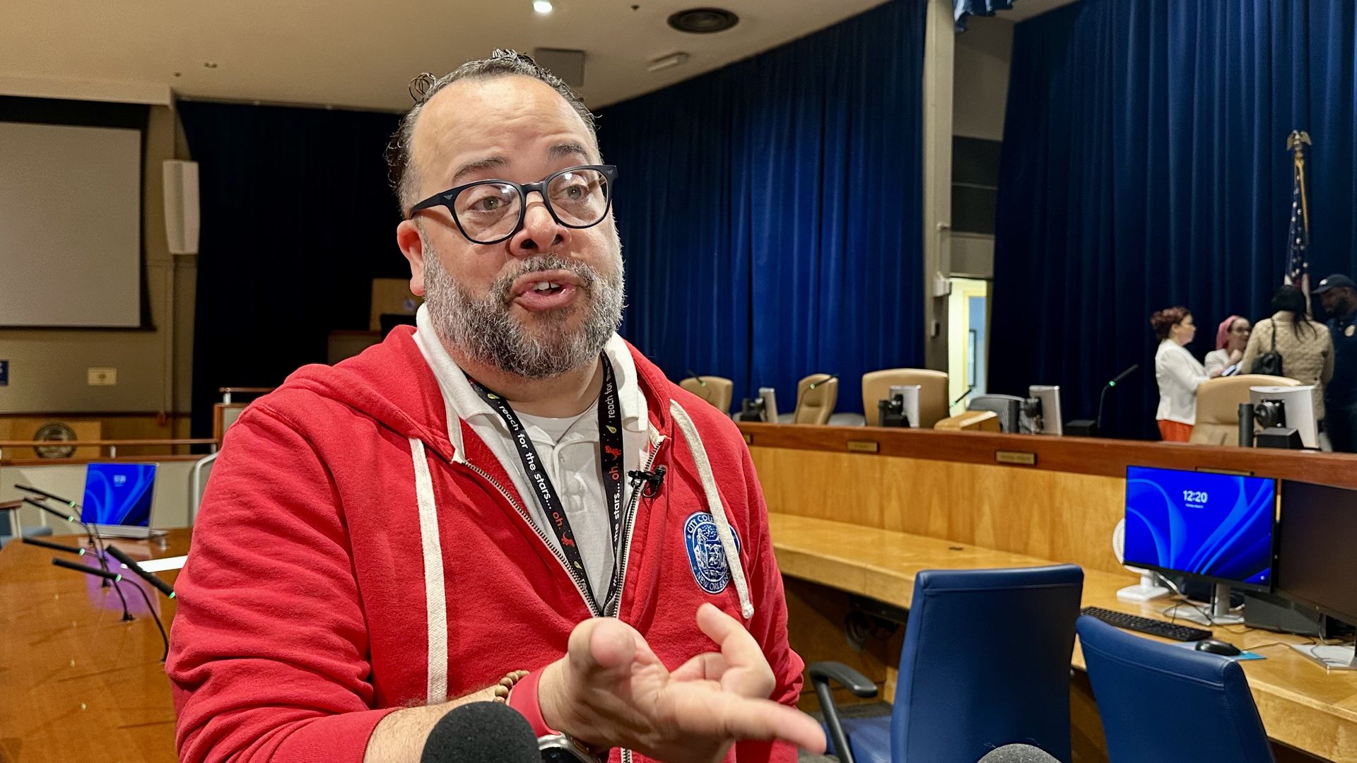 Image shows JP Morrell in a red hoodie in council chambers.