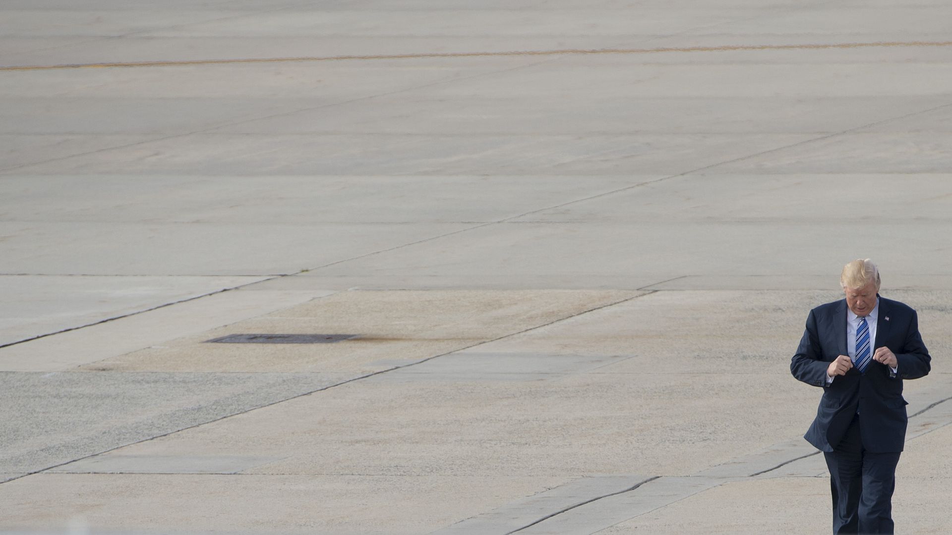 Photo of Donald Trump walking to Air Force One on a large, empty base