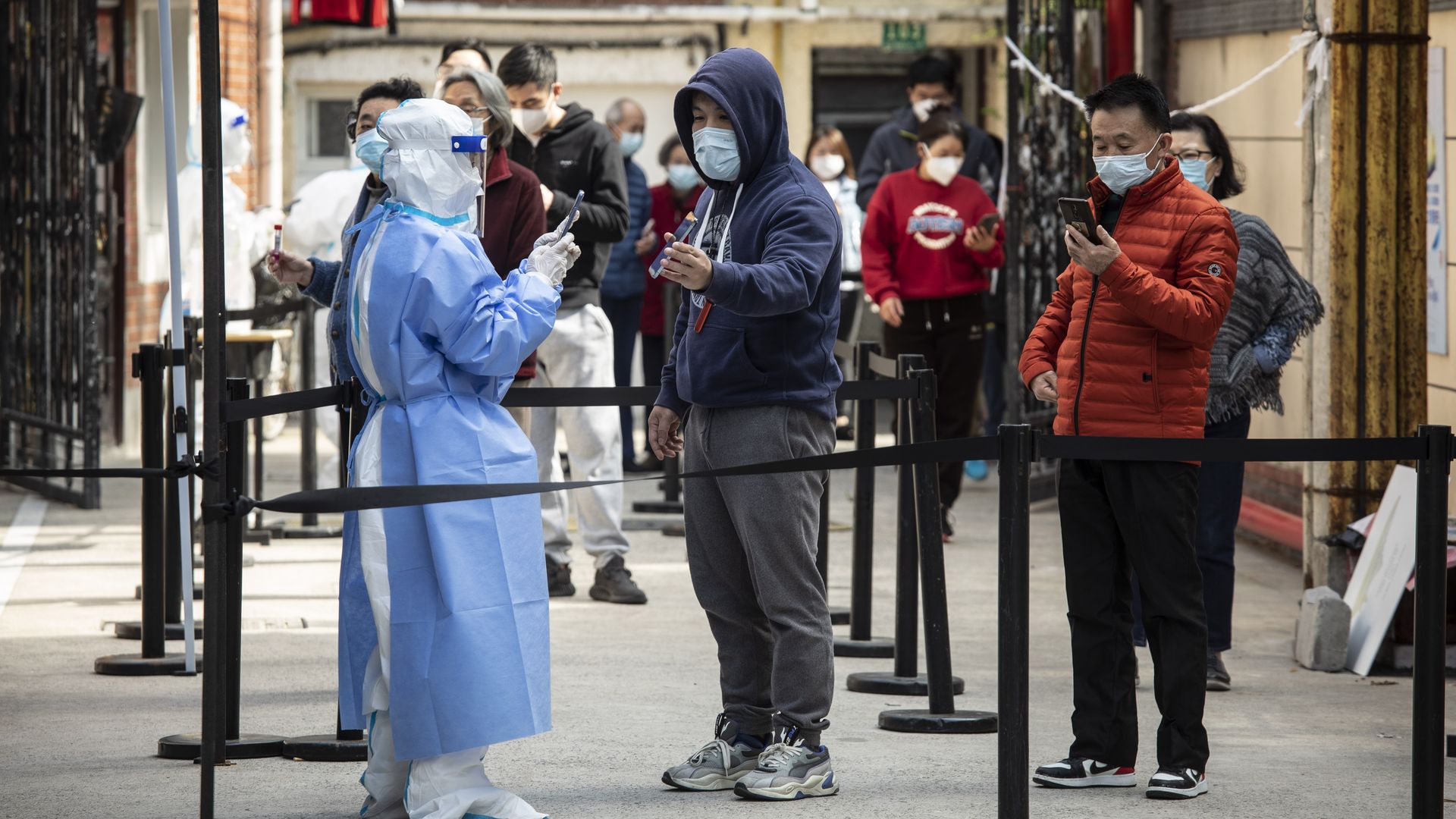 Residents show their health codes on mobile phones before taking part in a round of Covid-19 testing during a lockdown in Shanghai, China, on Monday, April 18