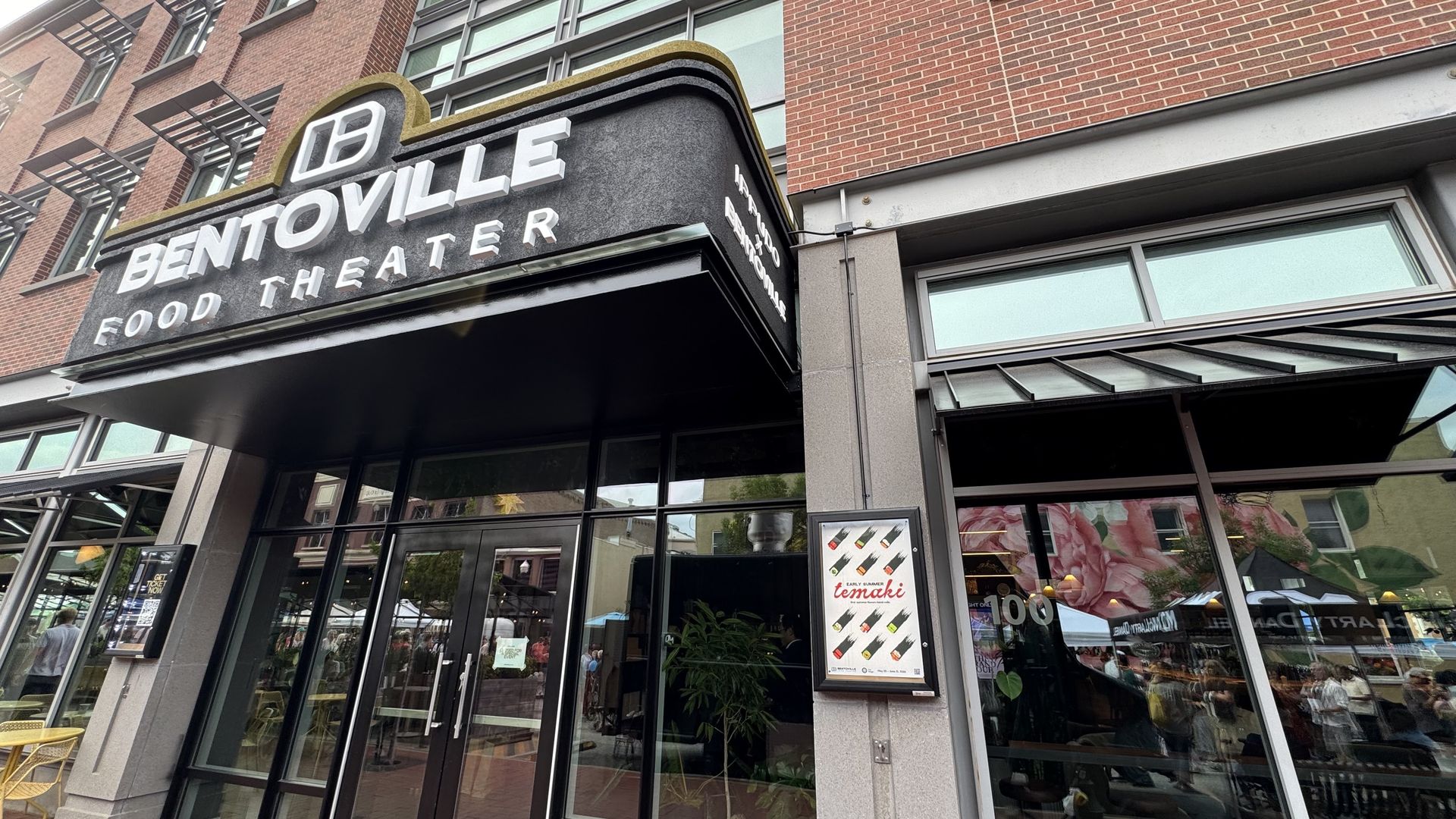 The entrance to Bentoville's Food Theater, a restaurant and event venue with a marquee-style sign on a brick building.