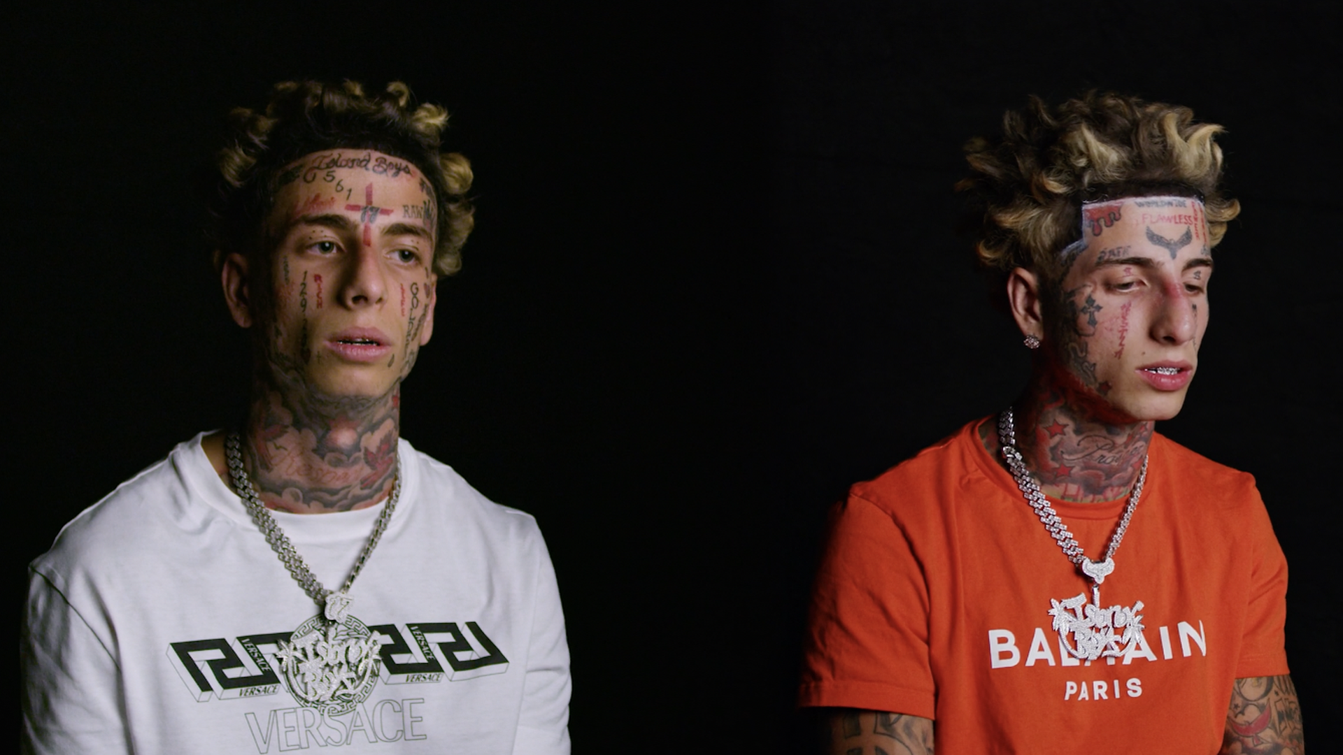 Two young guys with numerous tattoos on their faces. 