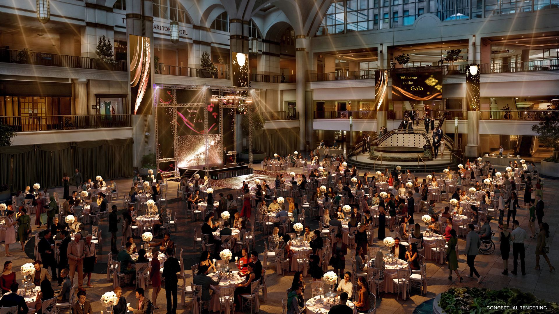 Large, elegant indoor gala event with many round tables, white floral centerpieces, guests in formal attire, and a stage under an arched ceiling with warm lighting.