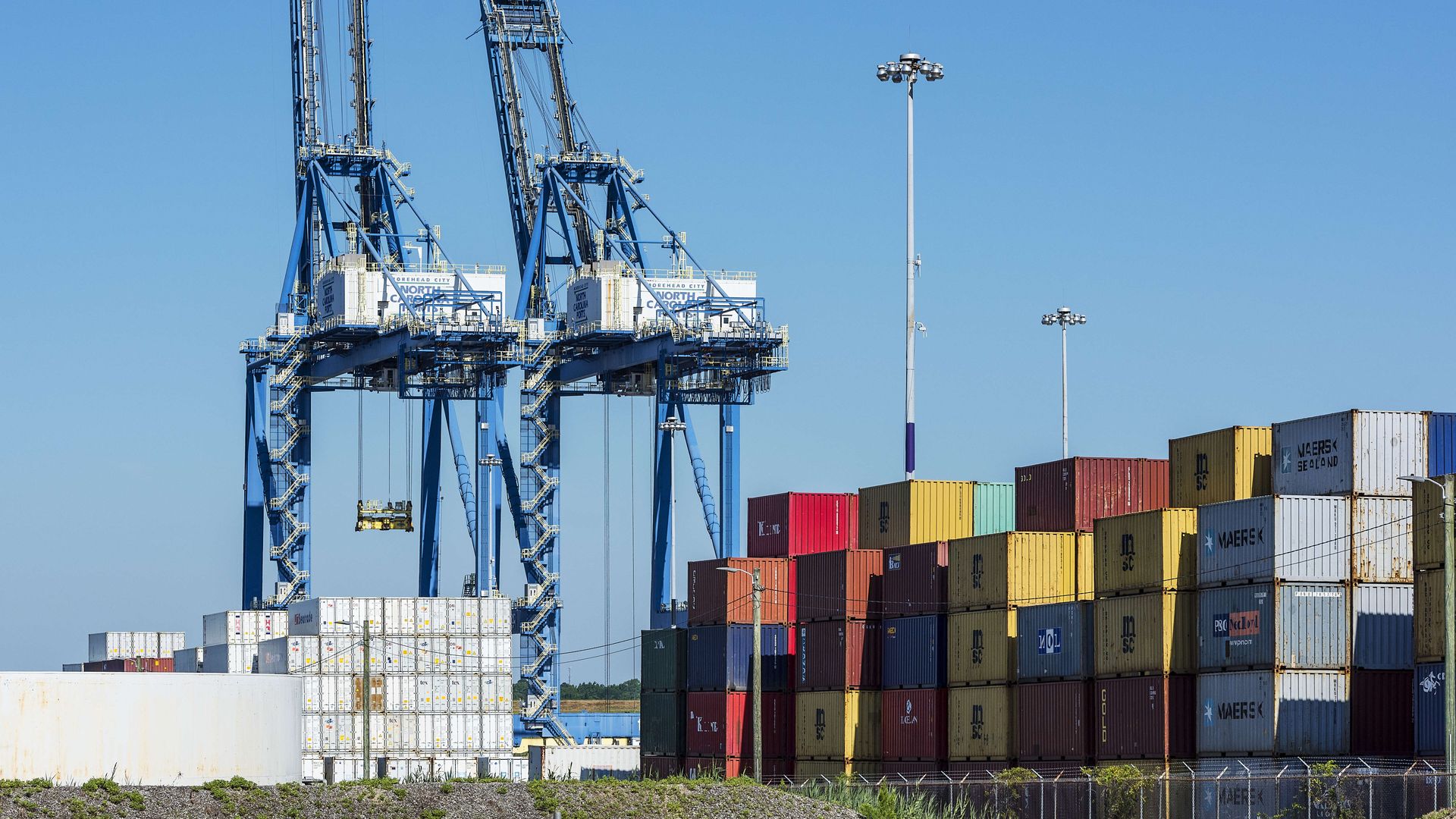 Brightly colored shipping containers and cranes at a port