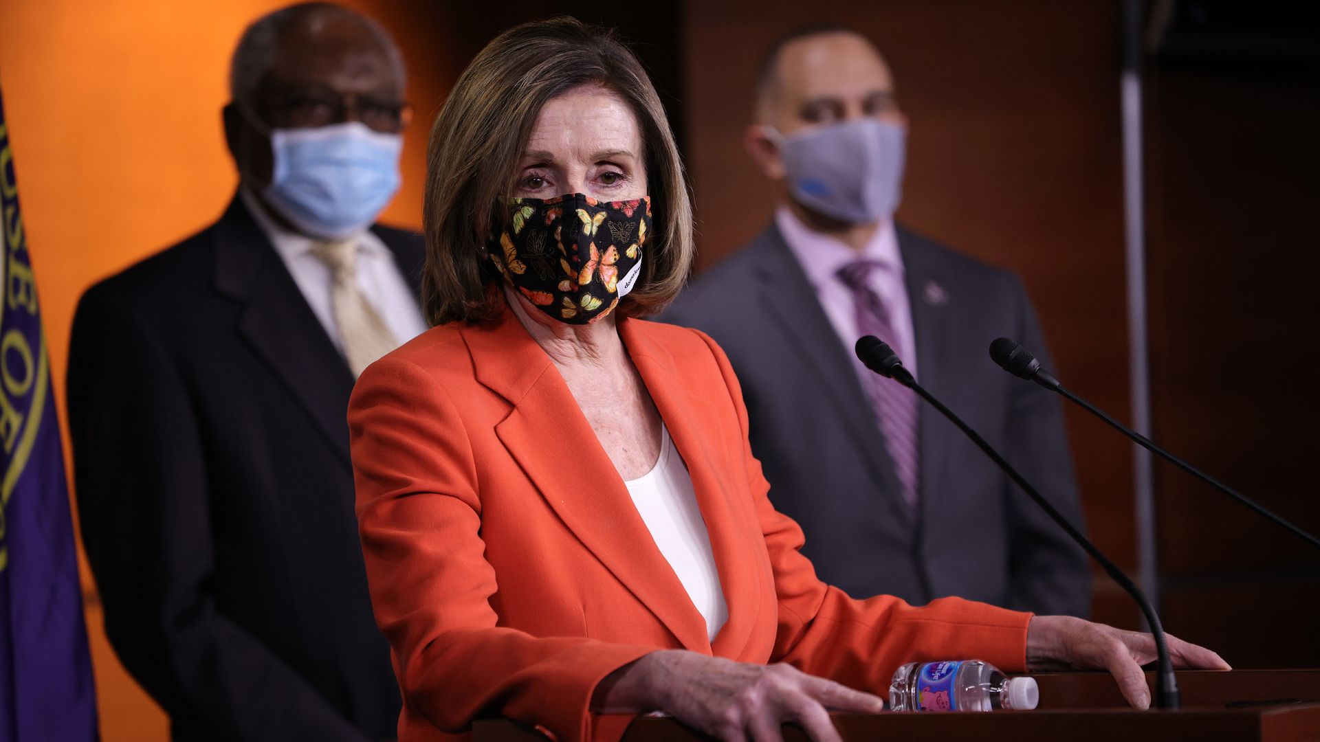 Photo of a masked Nancy Pelosi with two Congress members standing behind her