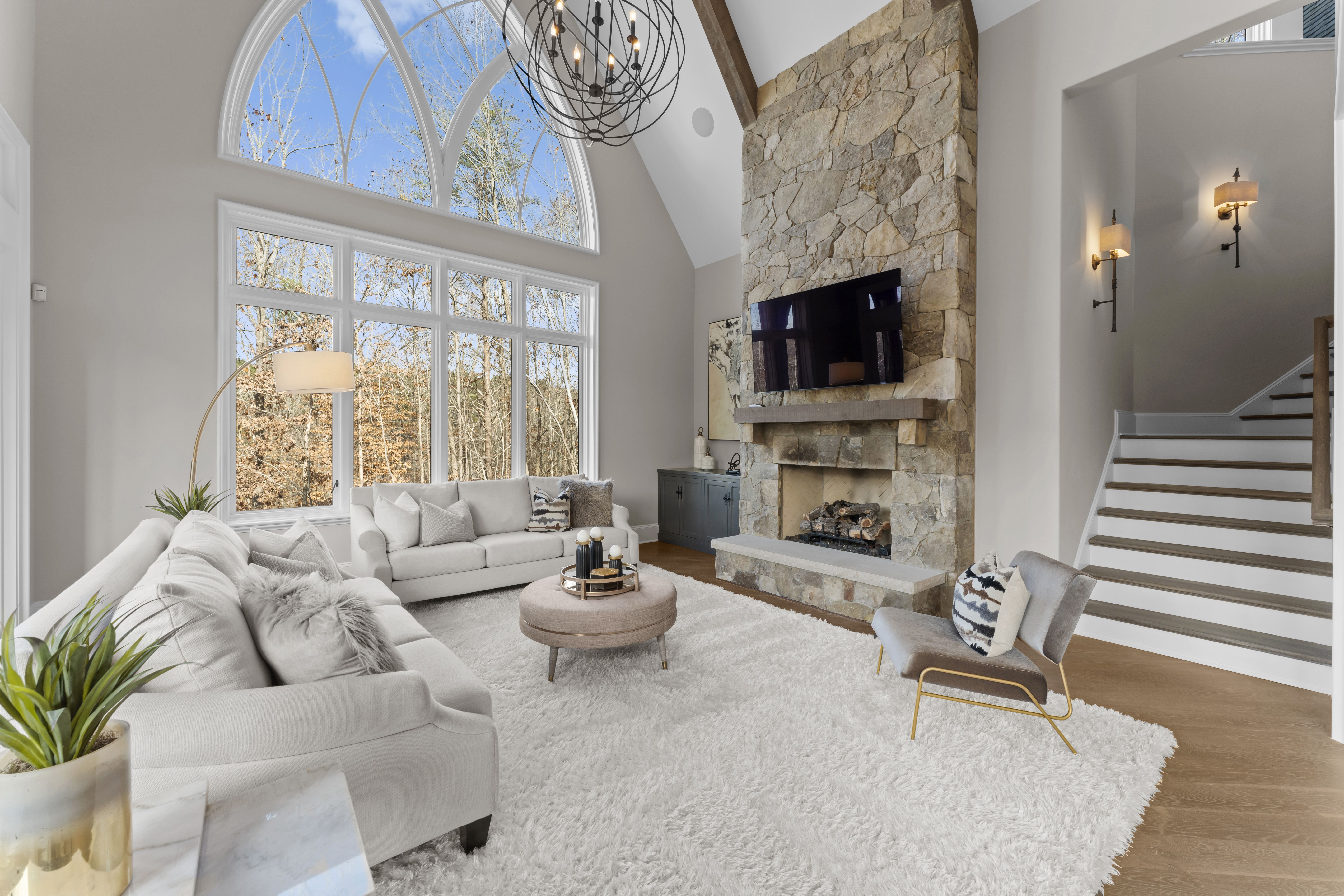 two-story great room with large window and stone fireplace
