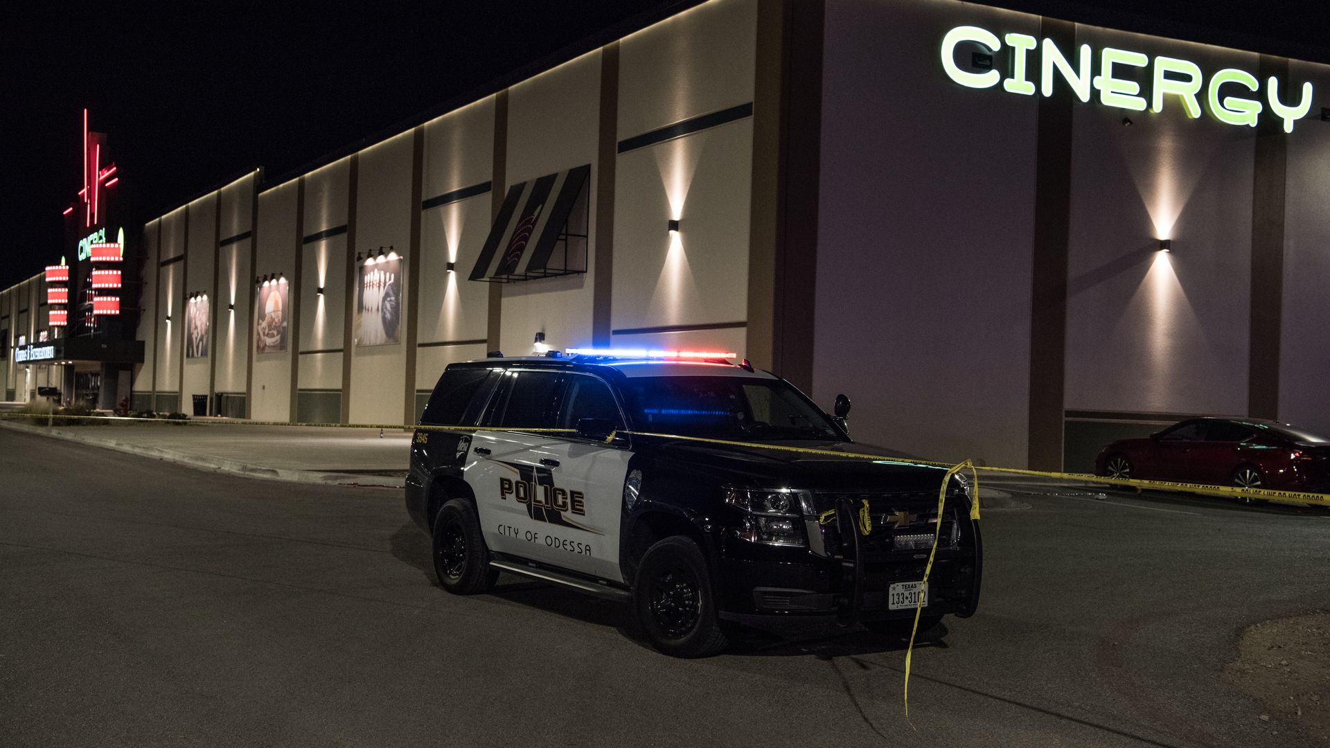 Police cars and tape block off a crime scene nearby to where a gunman was shot and killed at Cinergy Odessa movie theater