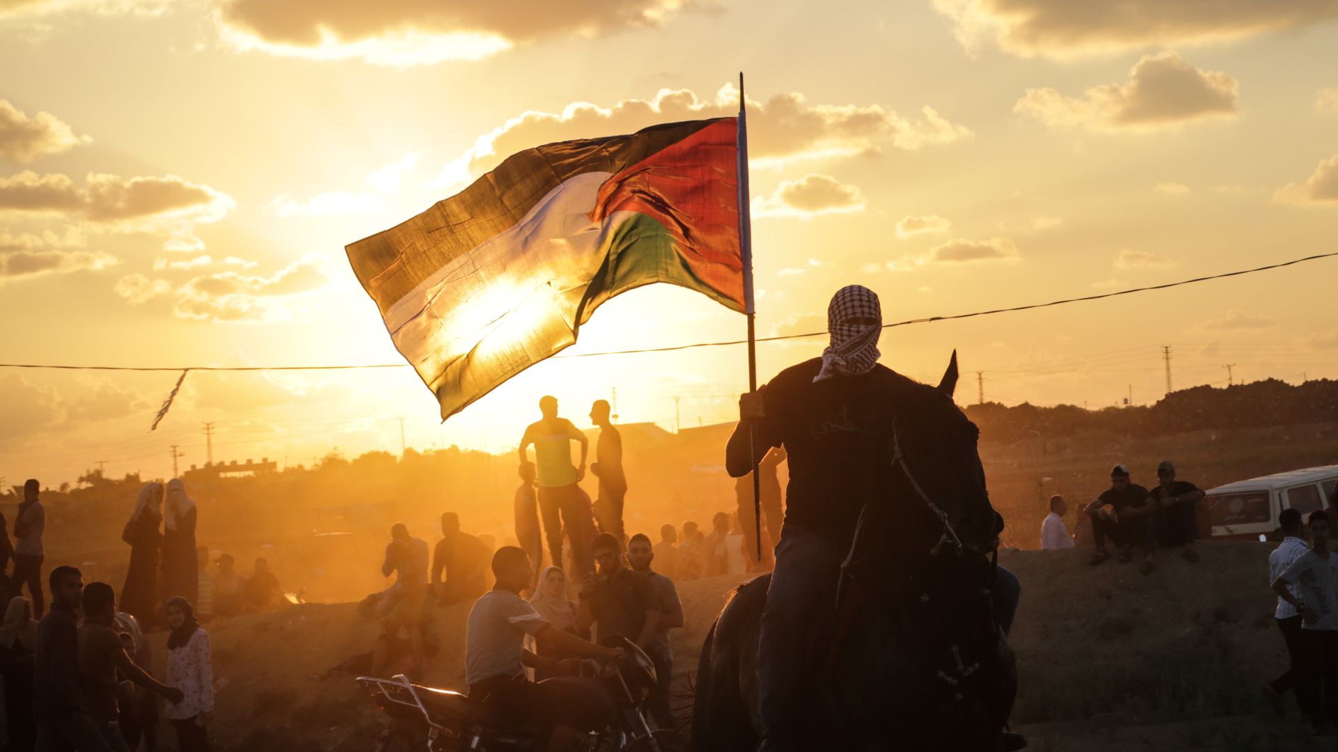 A Palestinian man riding a horse and waving a Palestinian flag during clashes between Palestinian protesters and the Israeli forces along the Israeli fence East of Gaza City.