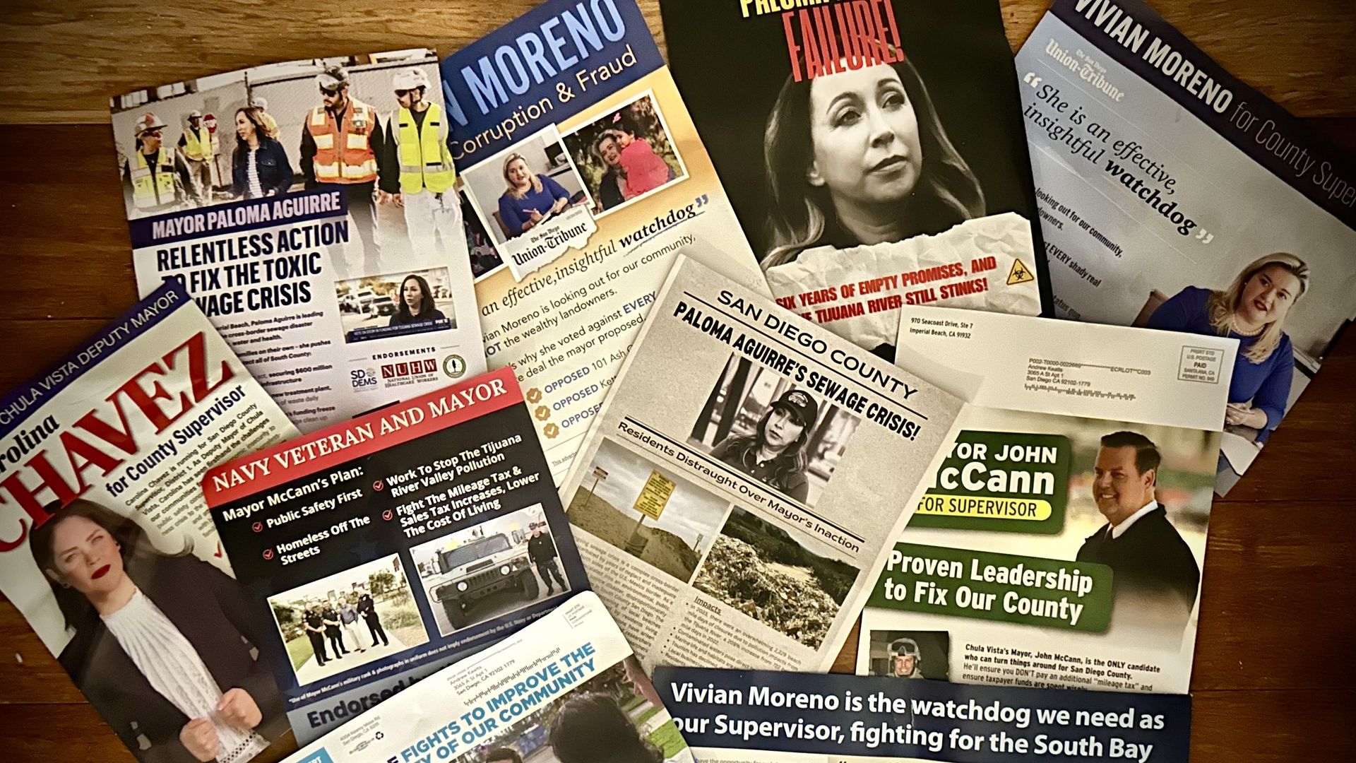 A scattered pile of campaign mailers including candidate voters, their names and words like "failure" and "corruption" and "marine" and "relentless action"