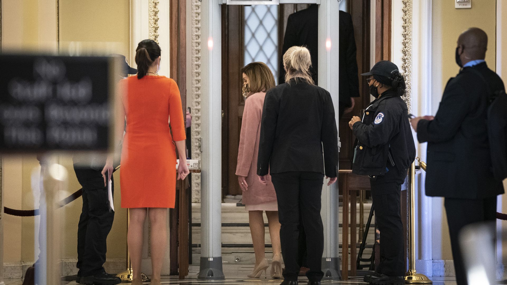 Speaker Nancy Pelosi is seen going through a metal detector before entering the House floor.