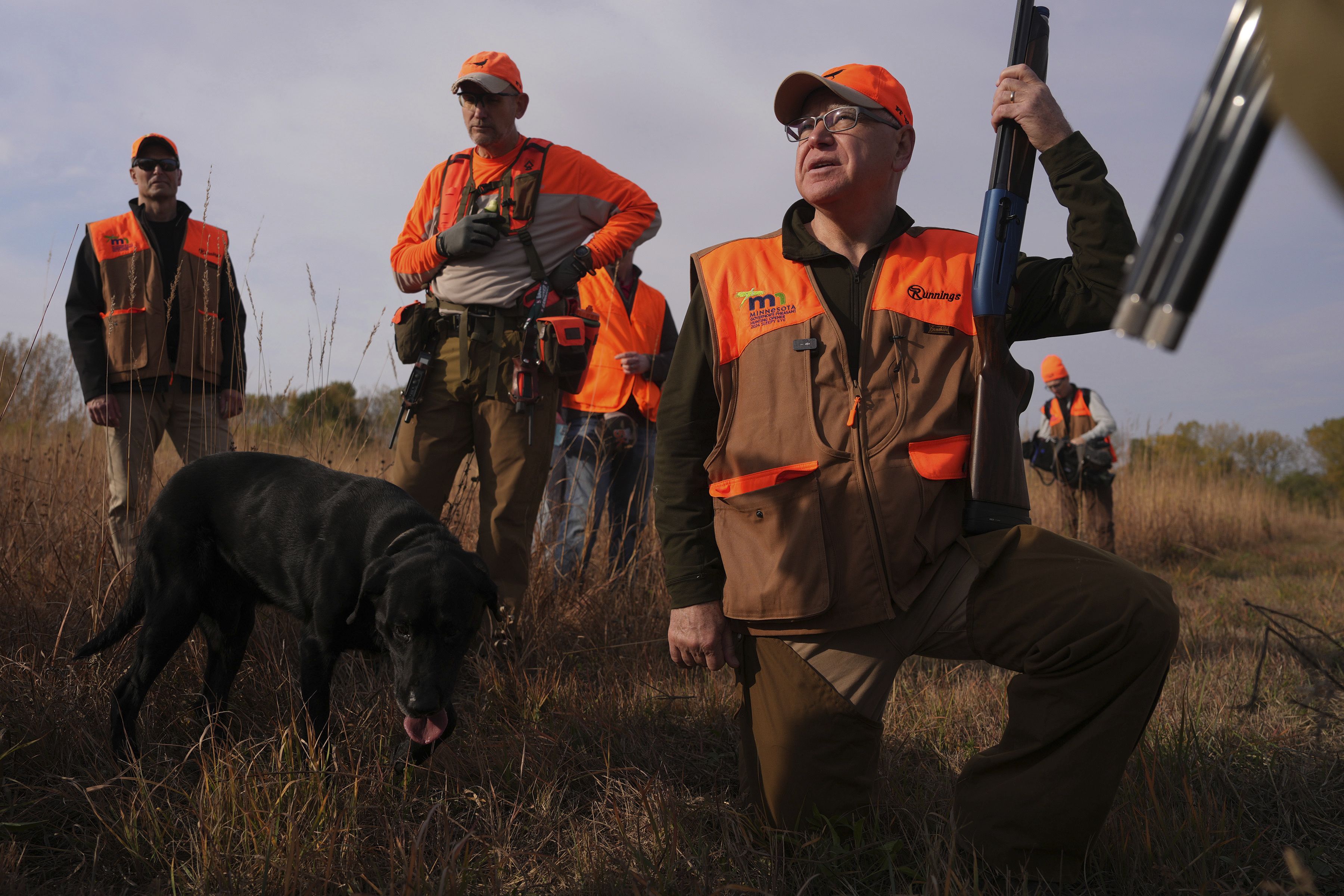 Flanked by his Secret Service detail, Tim Walz, Minnesota governor and Democratic vice presidential candidate, stops during a break to give water to the hunting dogs during the annual Minnesota Governor's Pheasant Hunting Opener near Sleepy Eye, Minn., Saturday