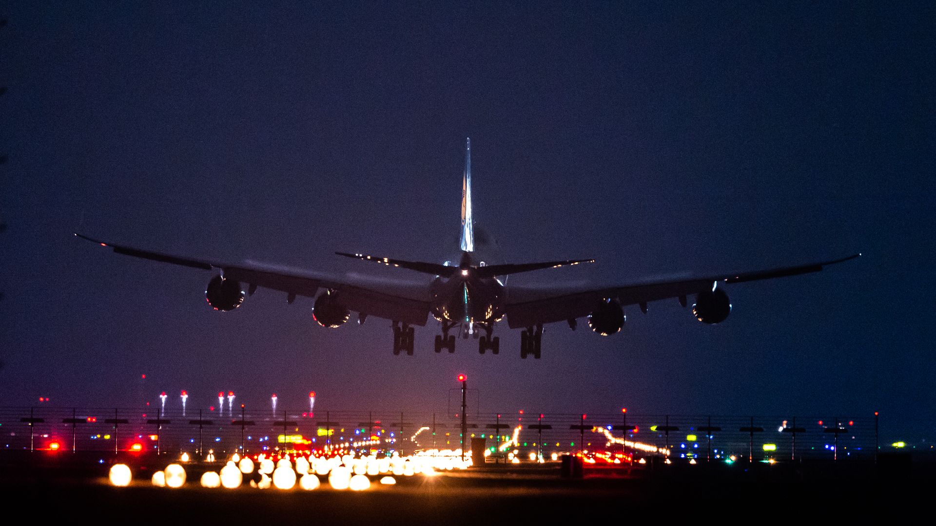 Airplane landing in dark sky.