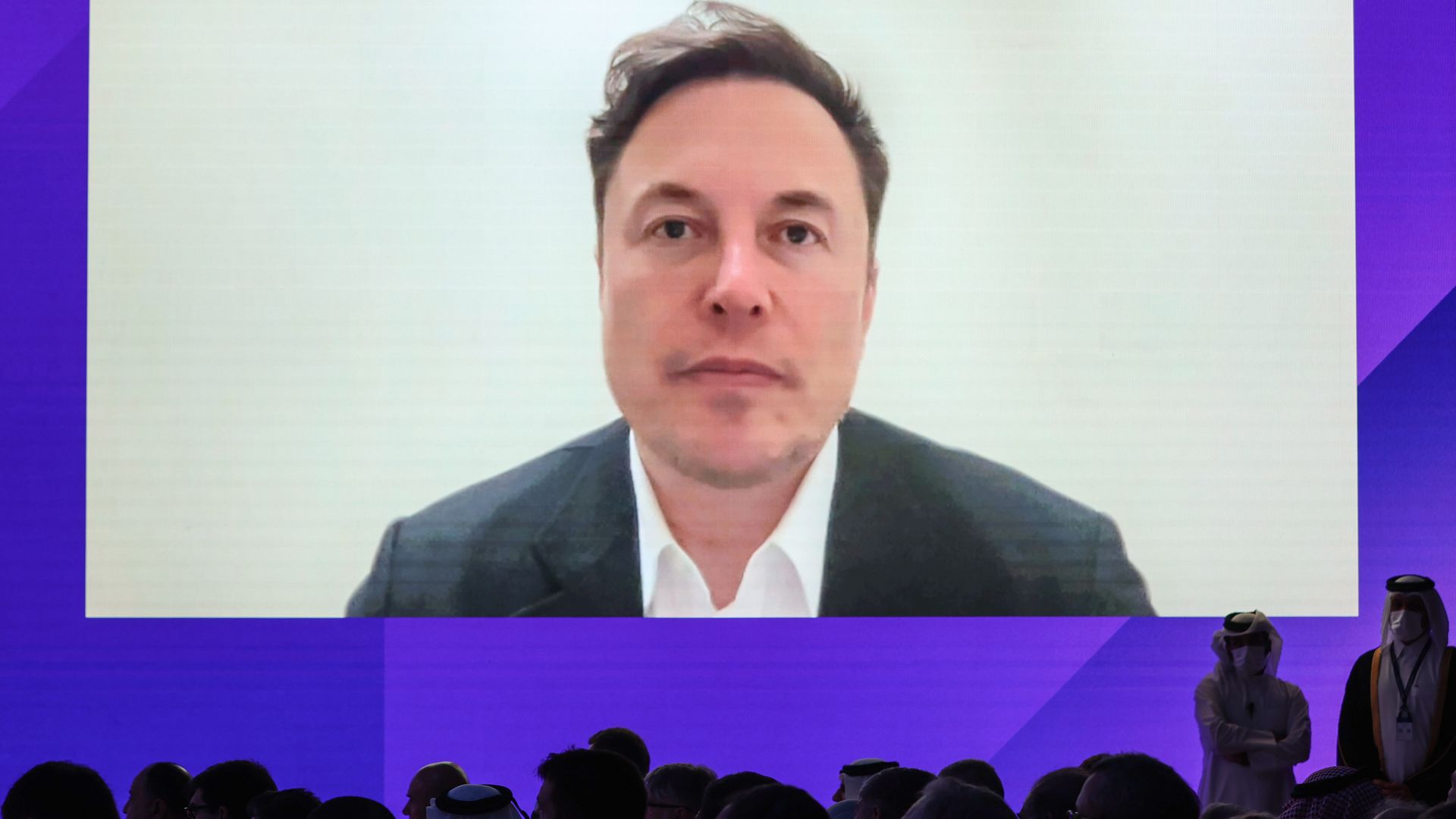 Elon Musk appearing via video link on a screen in Doha, Qatar, in June 2022.