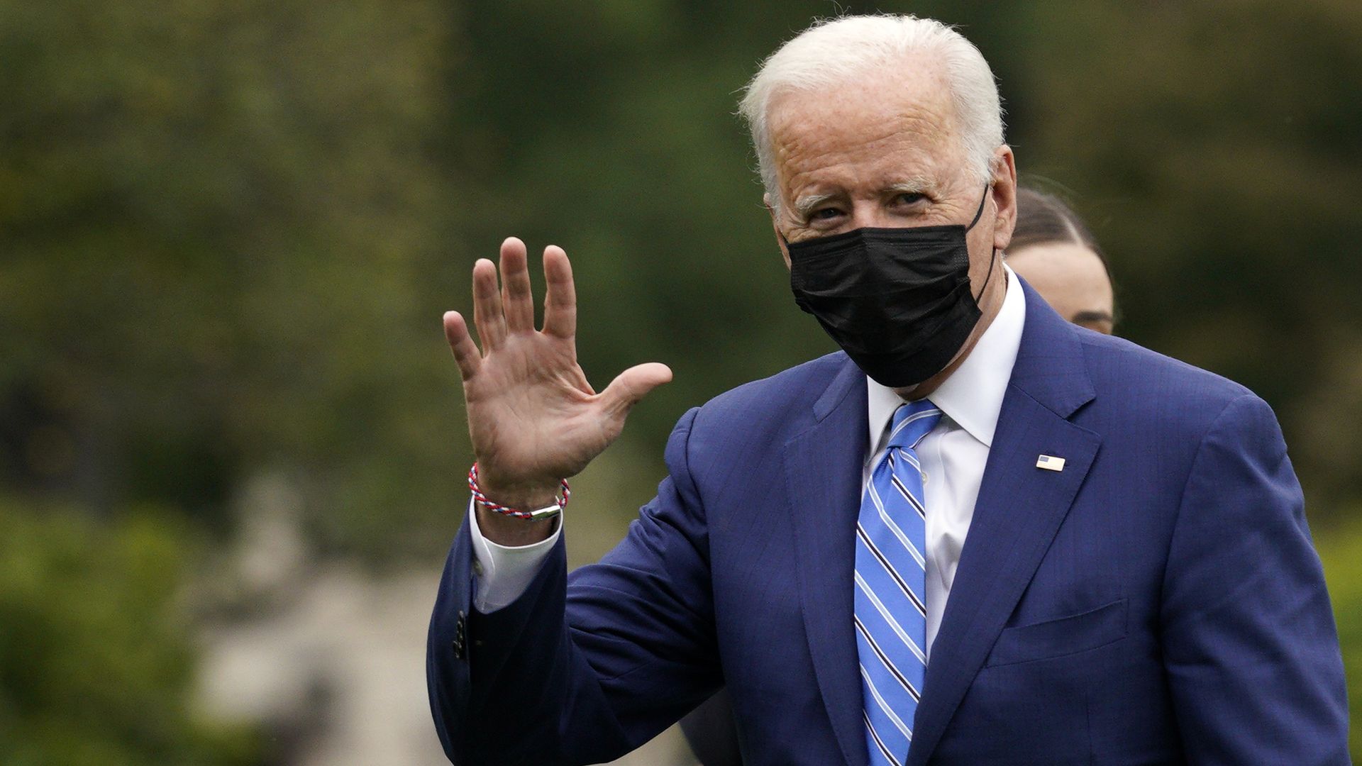 U.S. President Joe Biden walks and waves on the South Lawn of the White House after arriving on Marine One