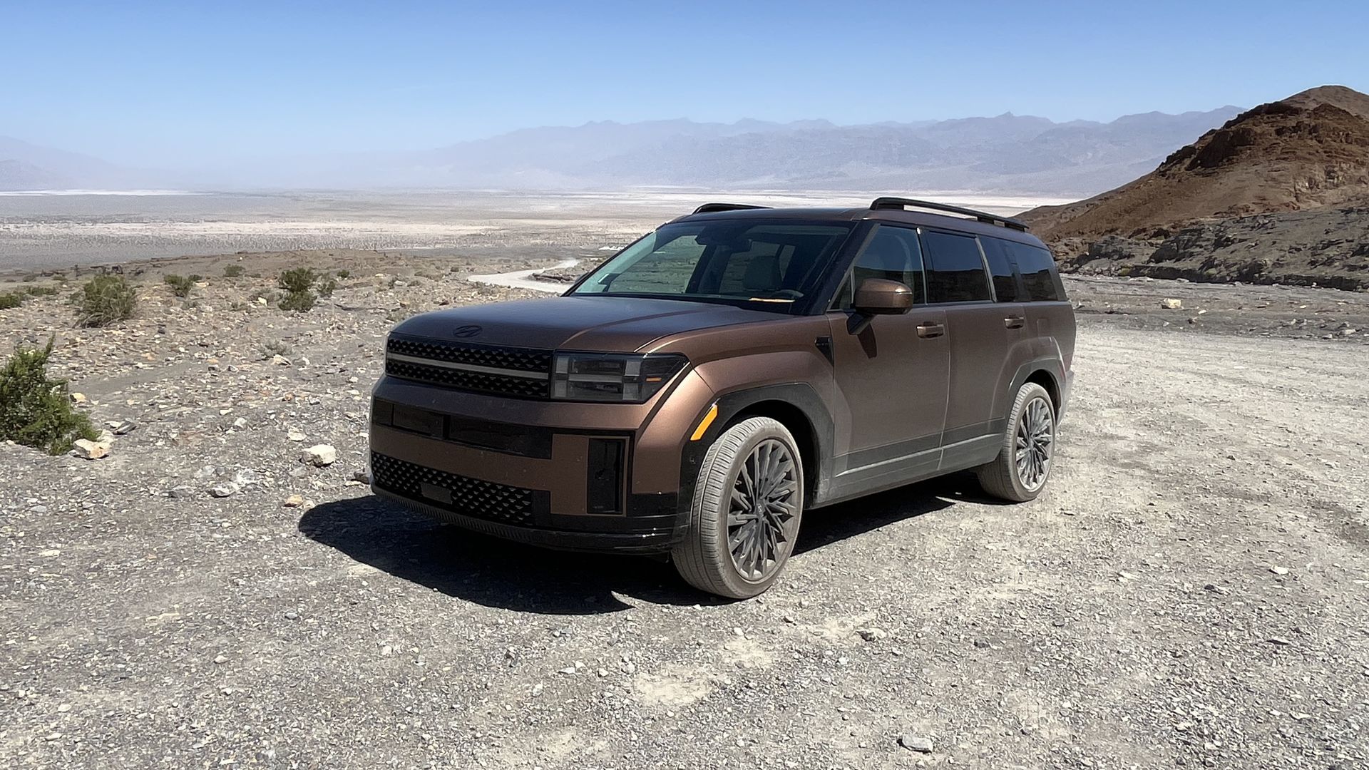 Image of a brass-colored 2024 Hyundai Santa Fe SUV parked on a dusty road in Death Valley National Park