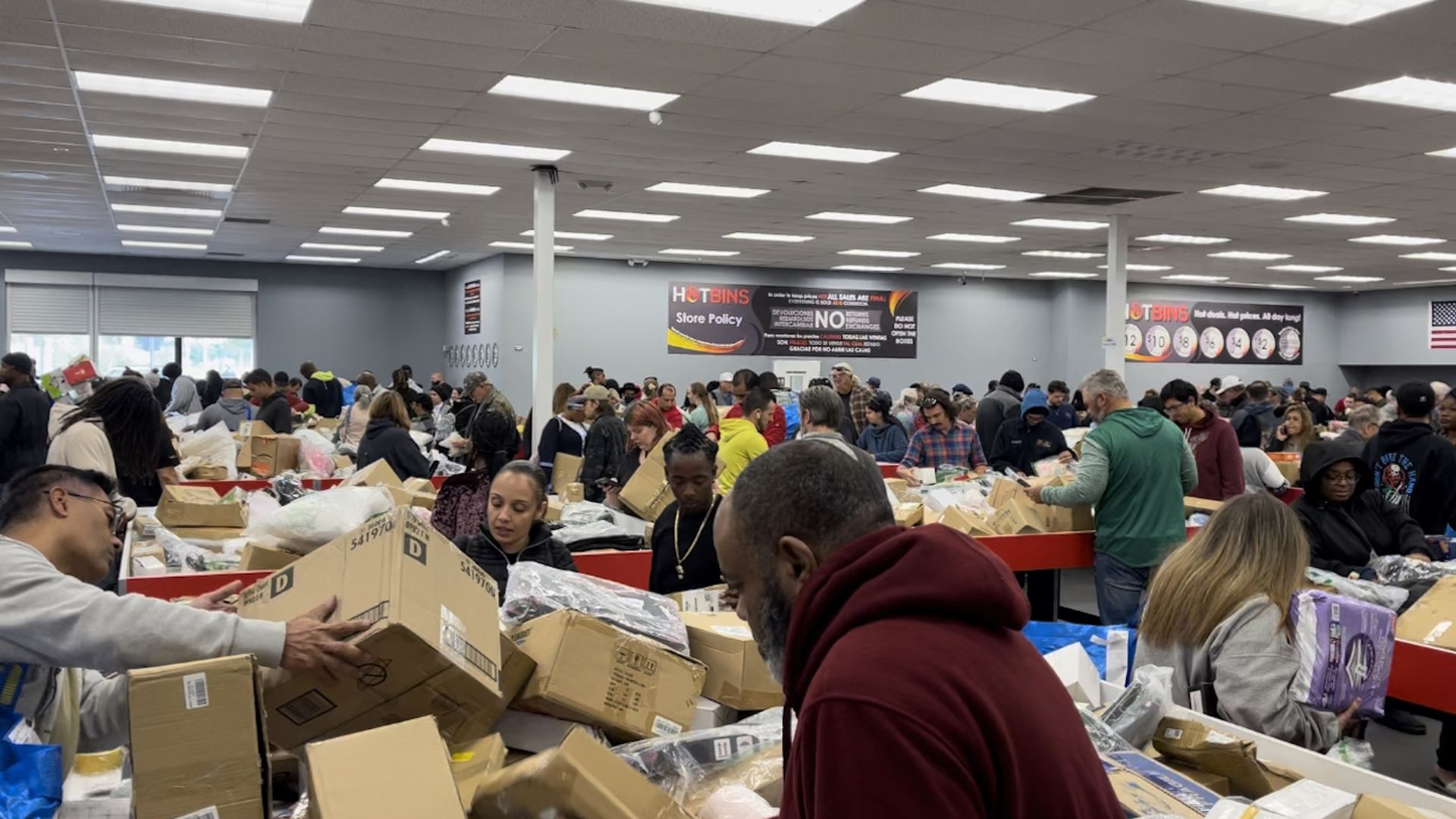 People dig through bins of boxed merchaindise at Hotbins