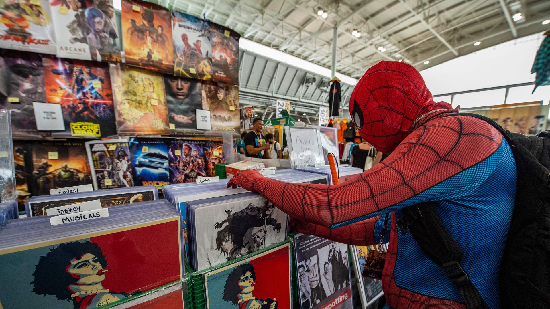 A man in a Spiderman costume looking at products