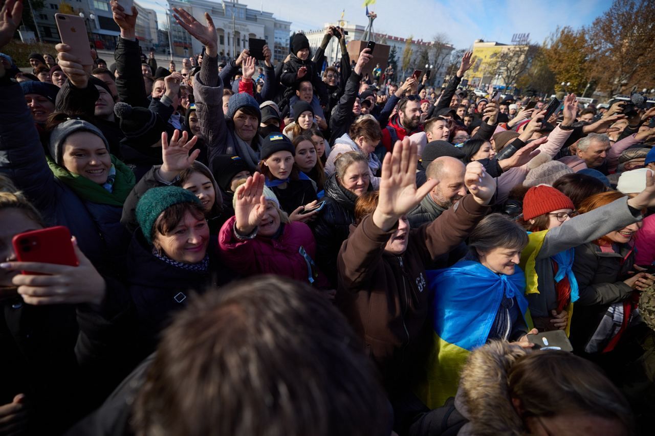 Ukrainian citizens wave their hands as the President Vladimir Zelensky meets Ukrainian soldiers and citizens after Russian retreat in Kherson Oblast, Ukraine on November 14, 2022. 