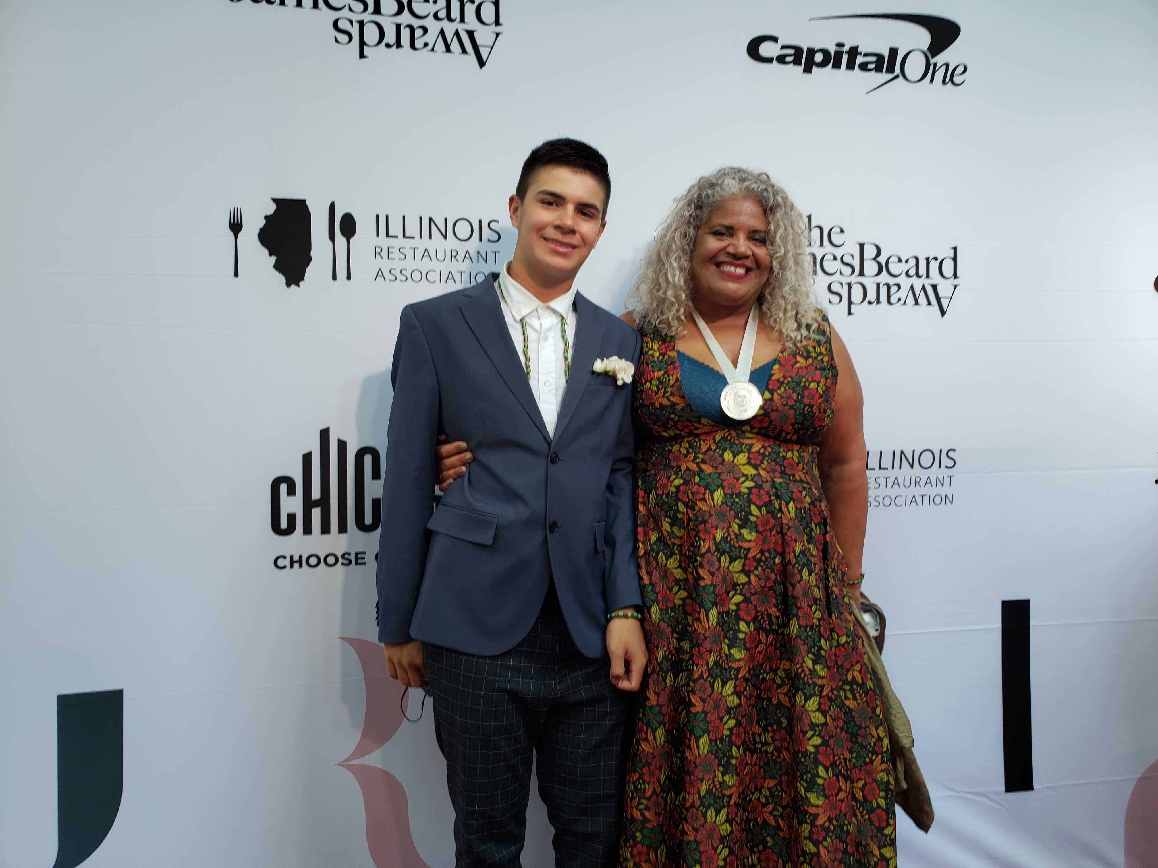 Photo of two people posing for camera on red carpet. 