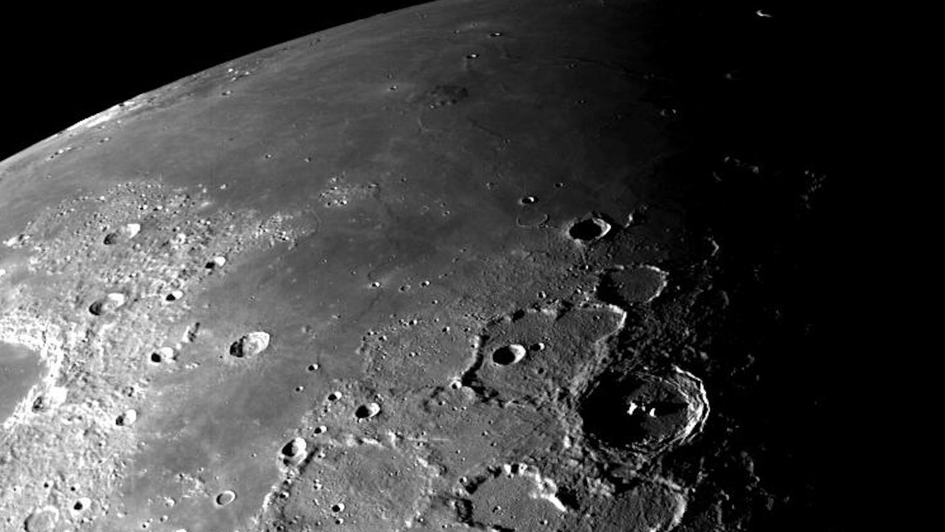 The Moon's surface in grey, with pocked craters