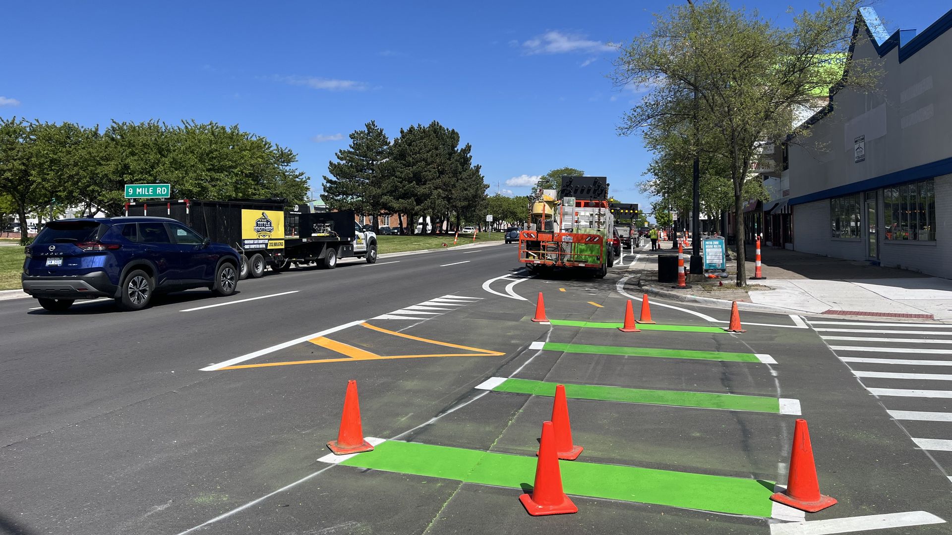 Traffic cones block off fresh green paint to alert bikers, drivers and pedestrians of the intersection.
