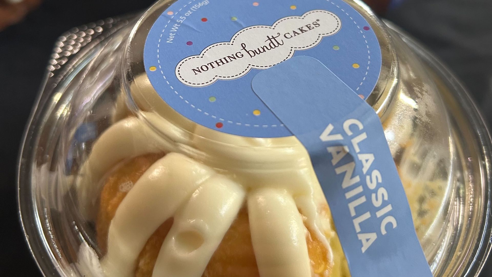 A close-up photo of a bundt cake in a plastic container
