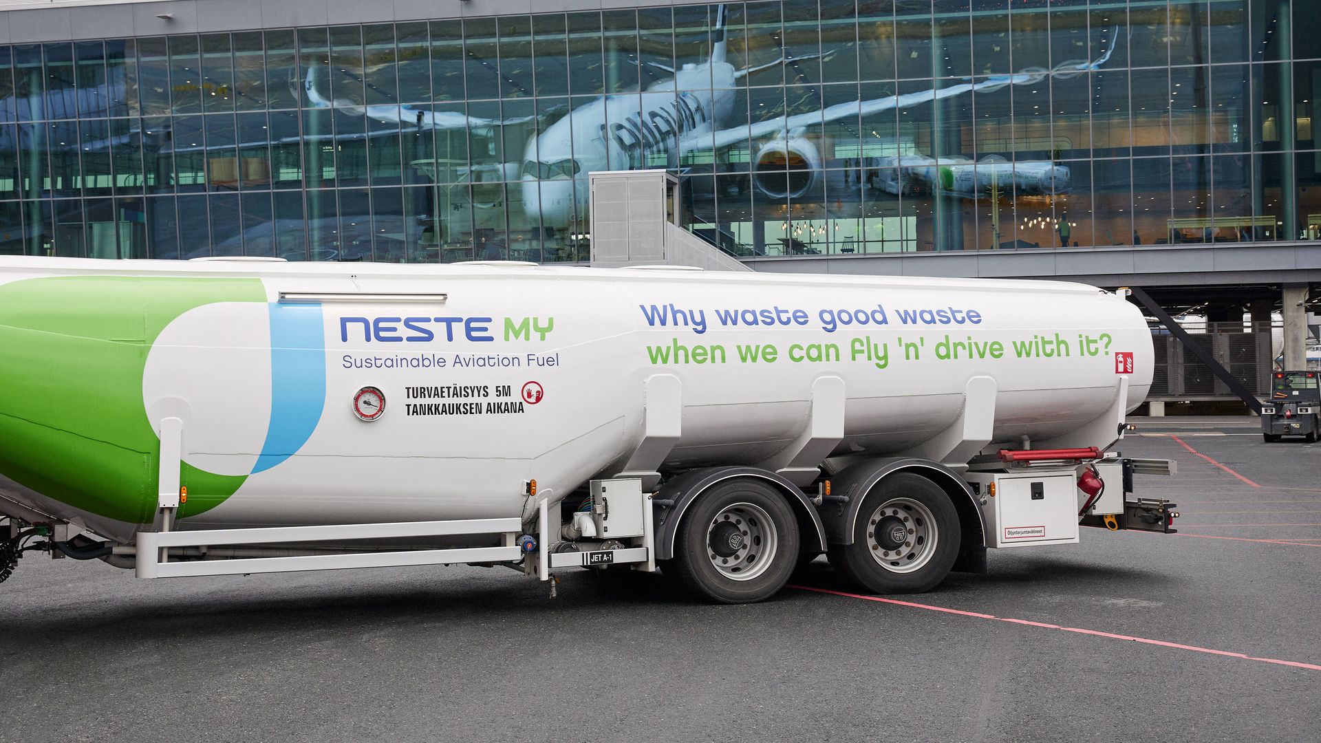 A Neste tanker truck carrying sustainable aviation fuel at an airport