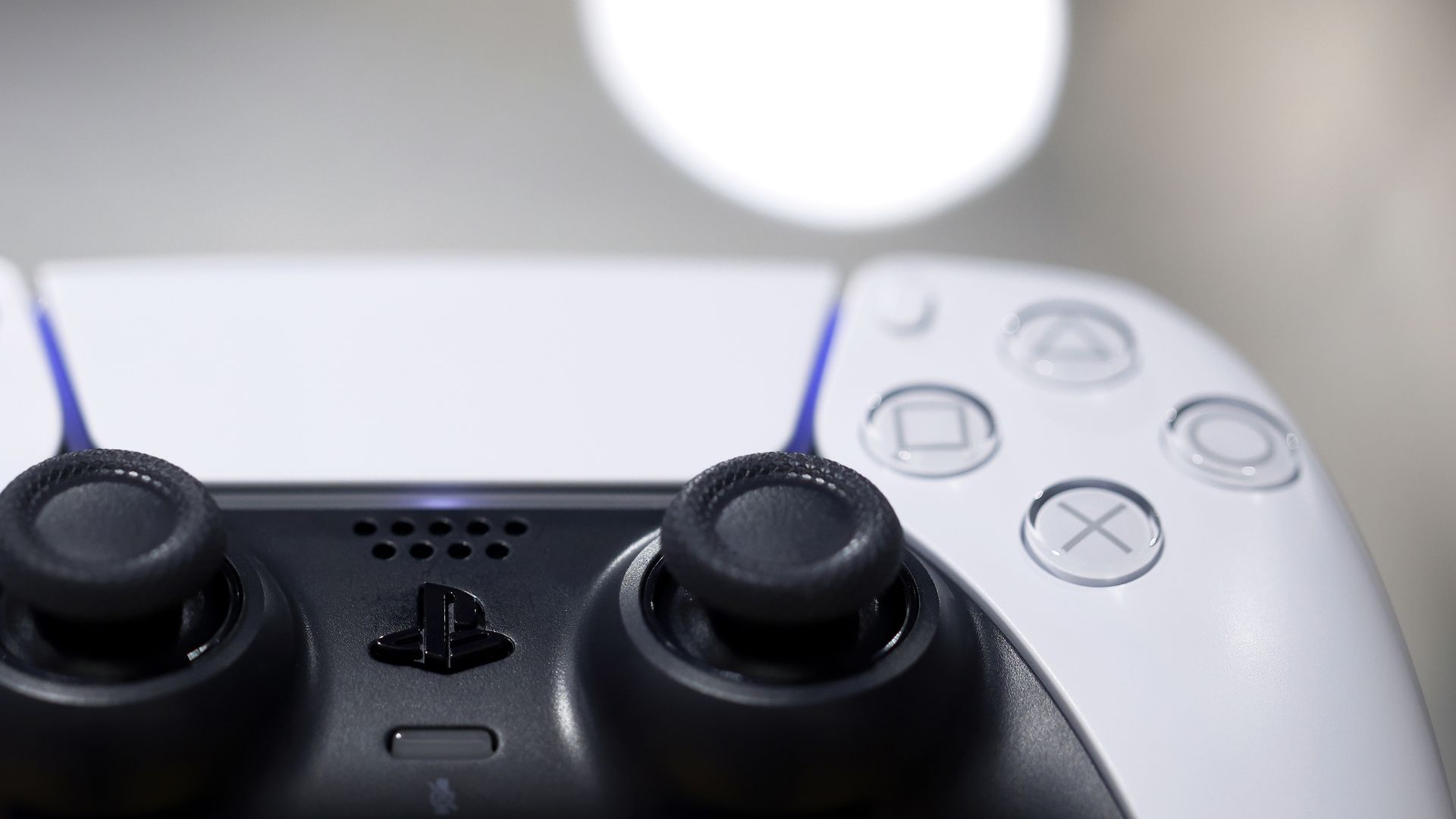 Close-up photograph of a white PlayStation 5 controller