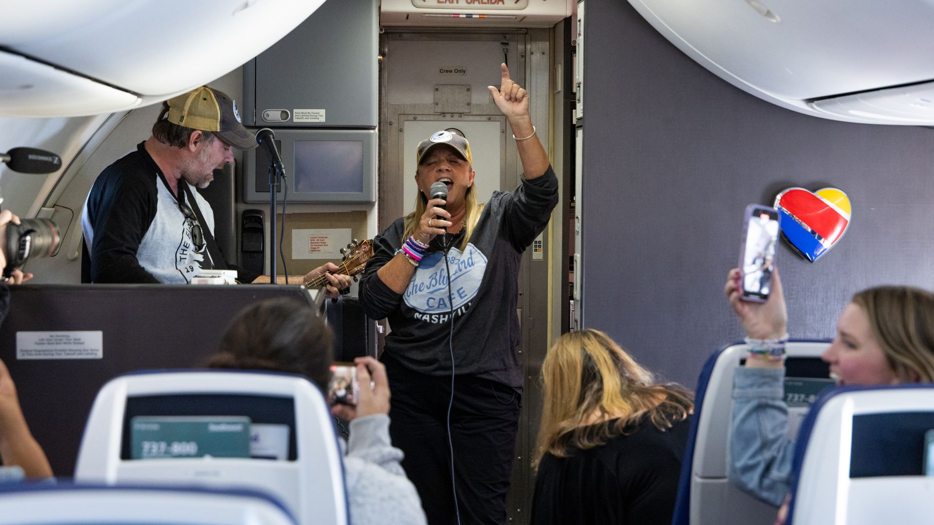 Liz Rose sings in the aisle of an airplane.