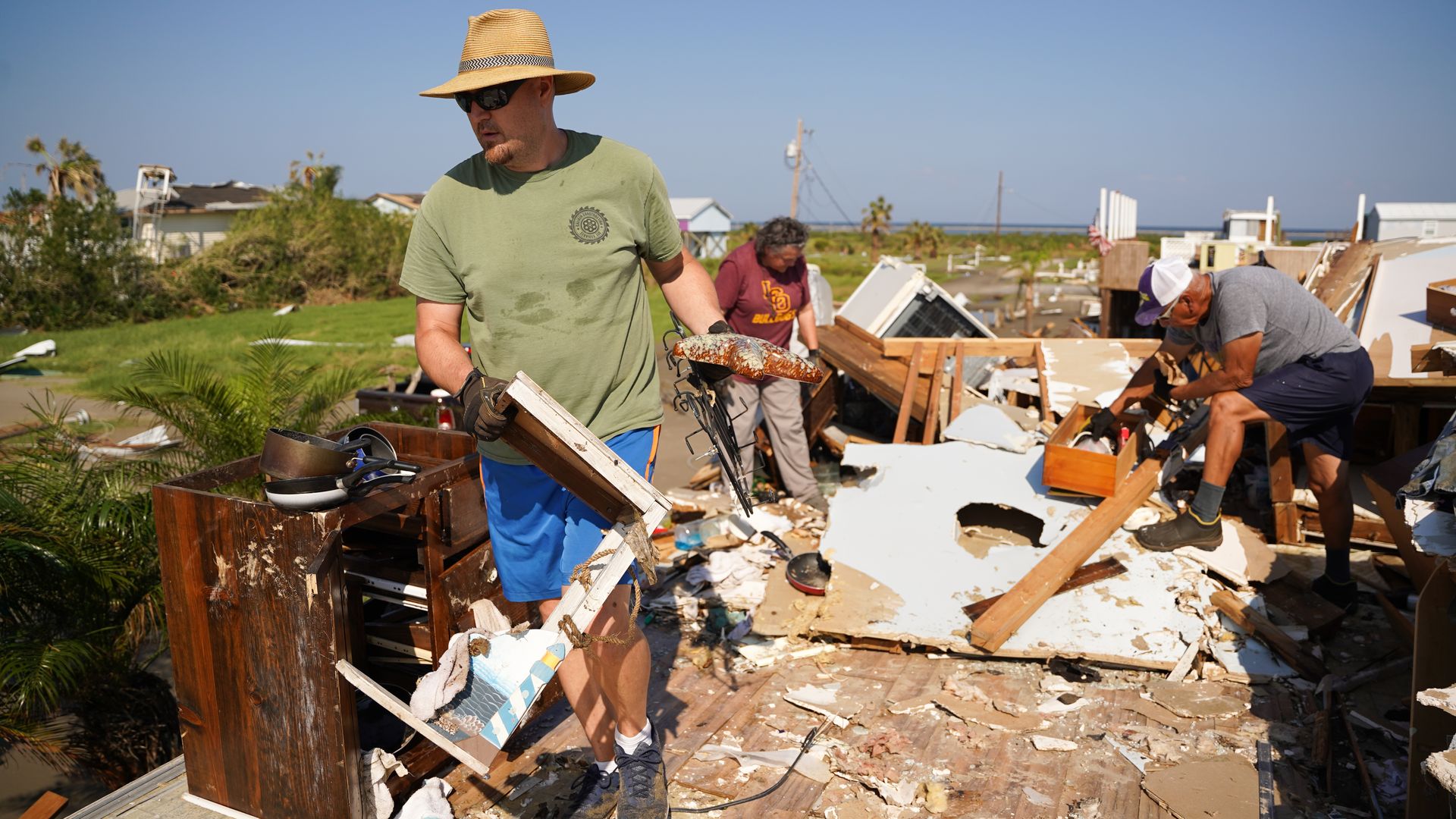 A family clean up their storm-damaged house after Hurricane Ida on September 4, 2021 in Grand Isle, Louisiana.