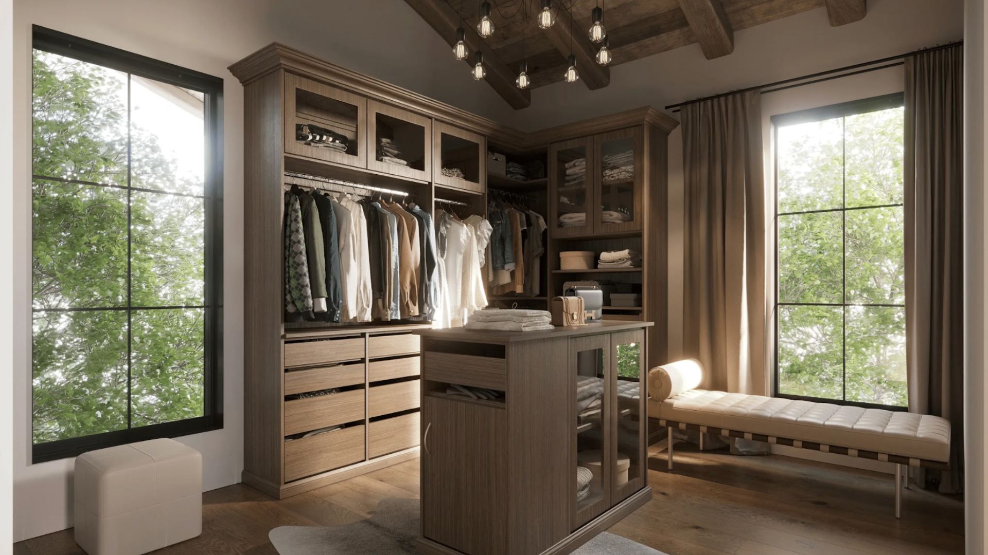 Warm, wood-toned walk-in closet with dark cabinetry, hanging clothes, open shelves, and a central island. Exposed beams, hanging bulbs, large windows showing greenery, and a beige bench along wall.