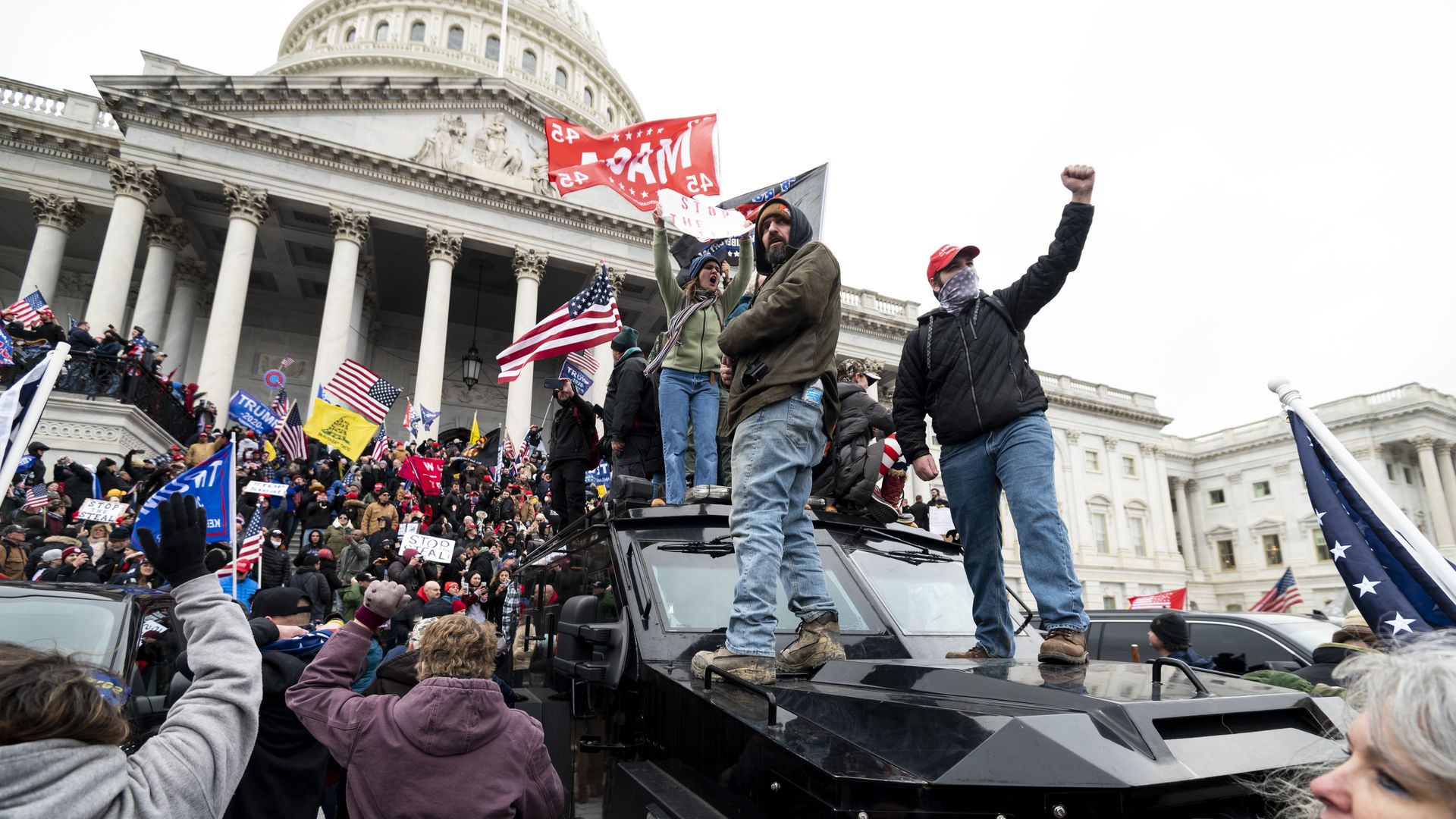 Trump supporters stand on the U.S. Capitol Police armored vehicle